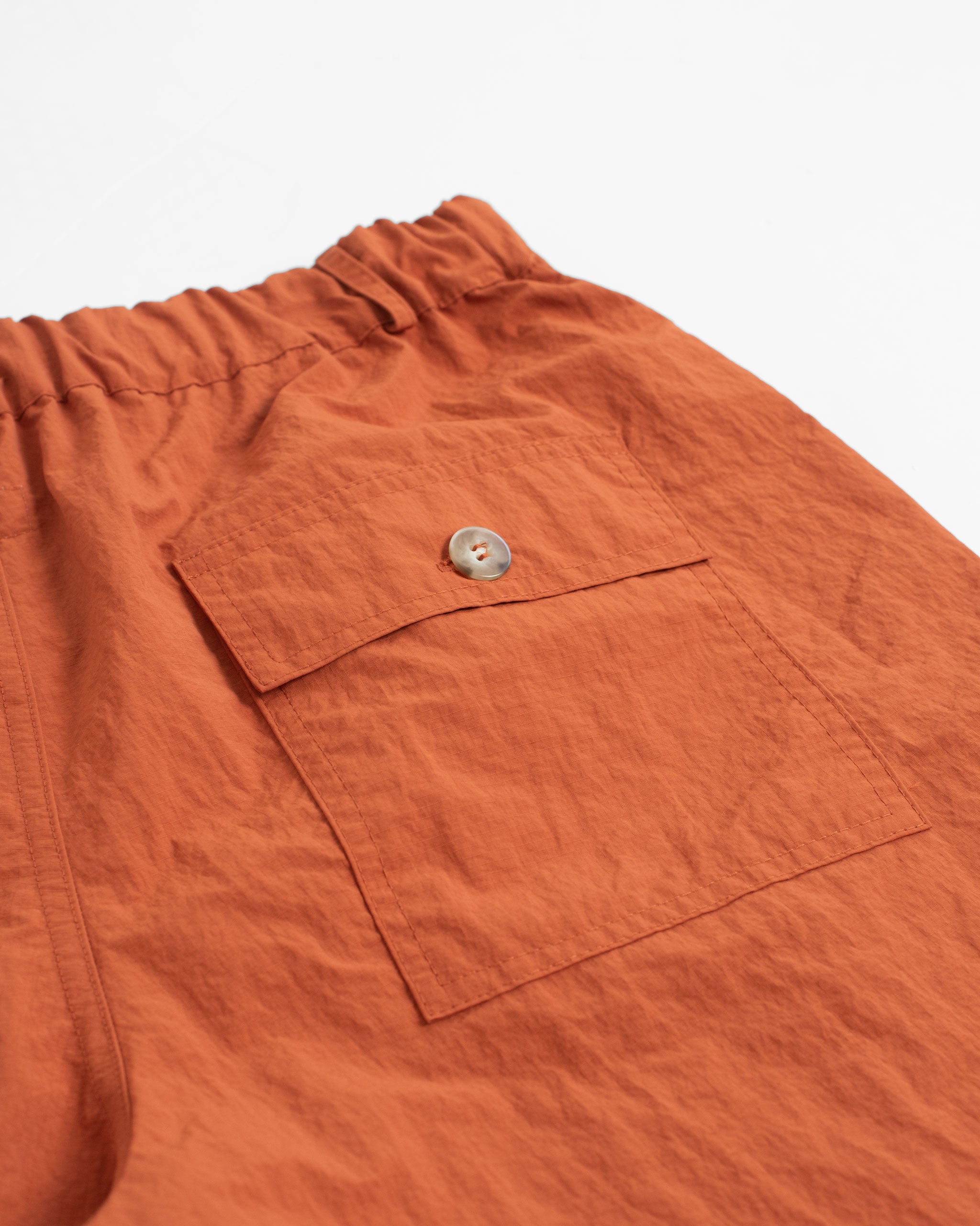 Solid Orange nylon utility with elasticized waist shorts back pocket close up
