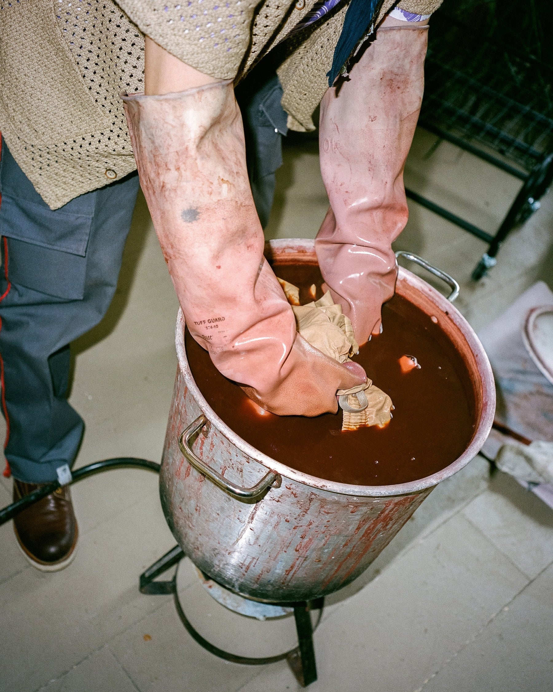 Person wearing gloves hand dyeing swim trunks