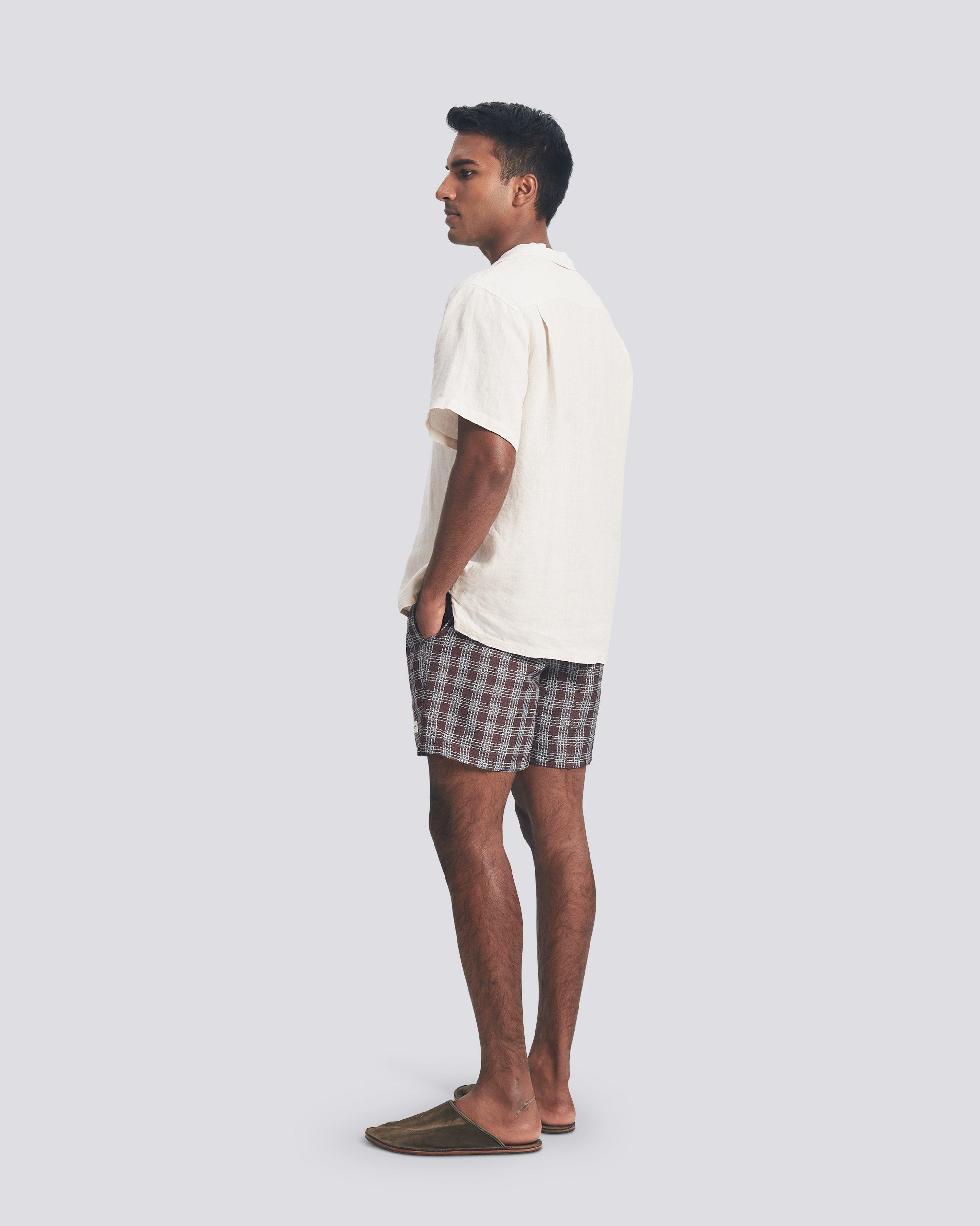 Male model wearing Bather plaid swim trunks with a Bather white camp shirt