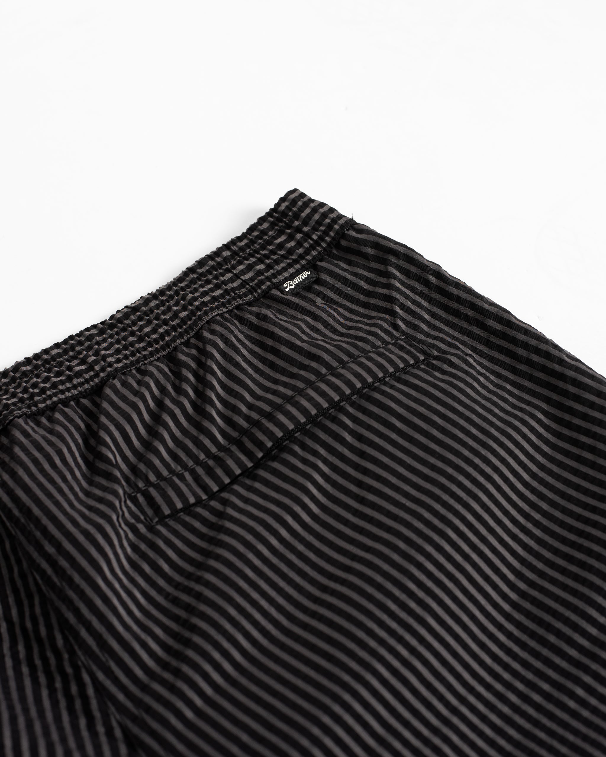 Close-up of men’s black pinstripe swim trunk with hidden zipper closure pocket