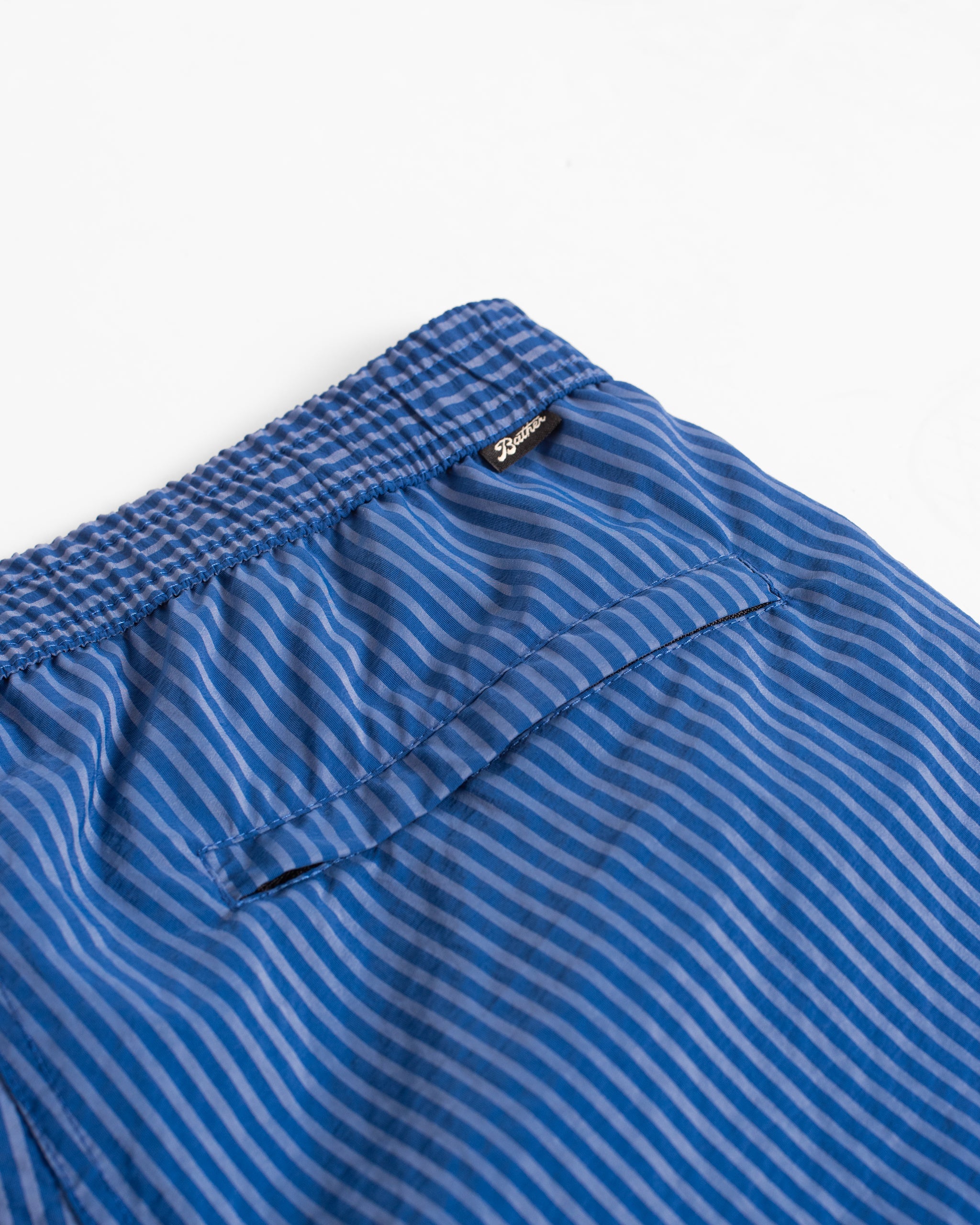 Close-up of men’s blue pinstripe swim trunk with hidden zipper closure pocket