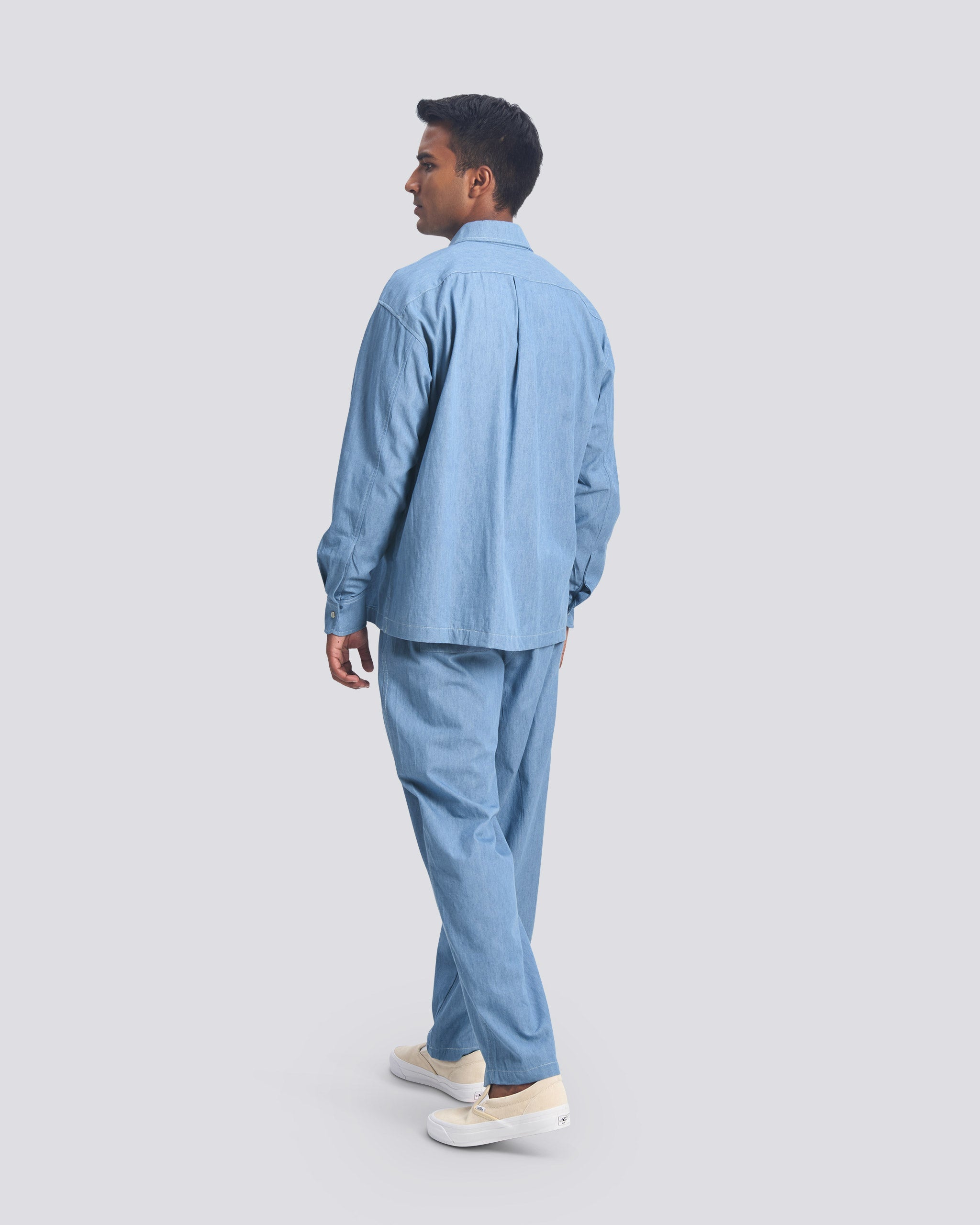 Rear view of a model wearing the Bather Men's light blue denim leisure set.