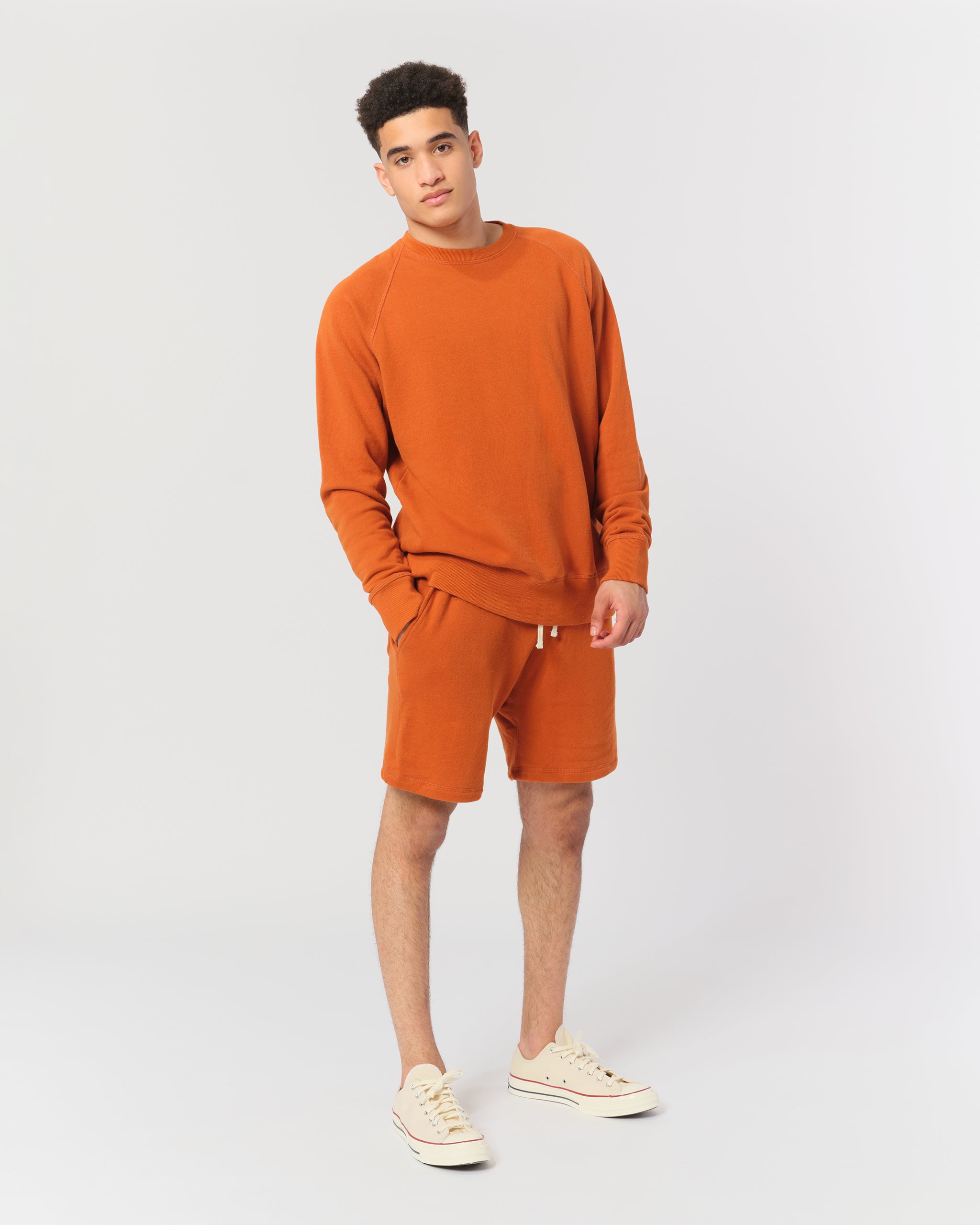 model wearing Orange french terry raglan sleeve crewneck sweatshirt