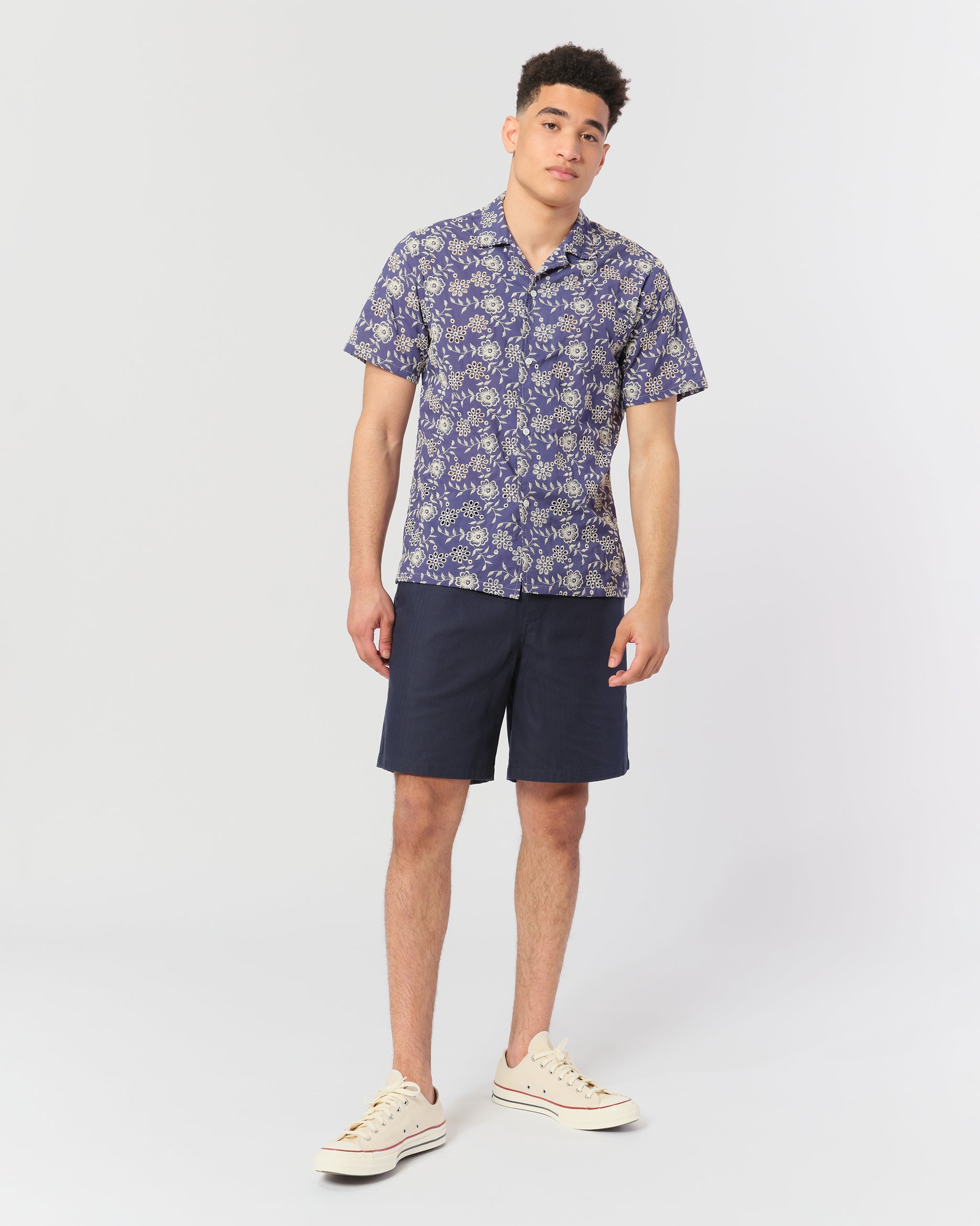 model wearing Blue camp shirt with an embroidered floral pattern