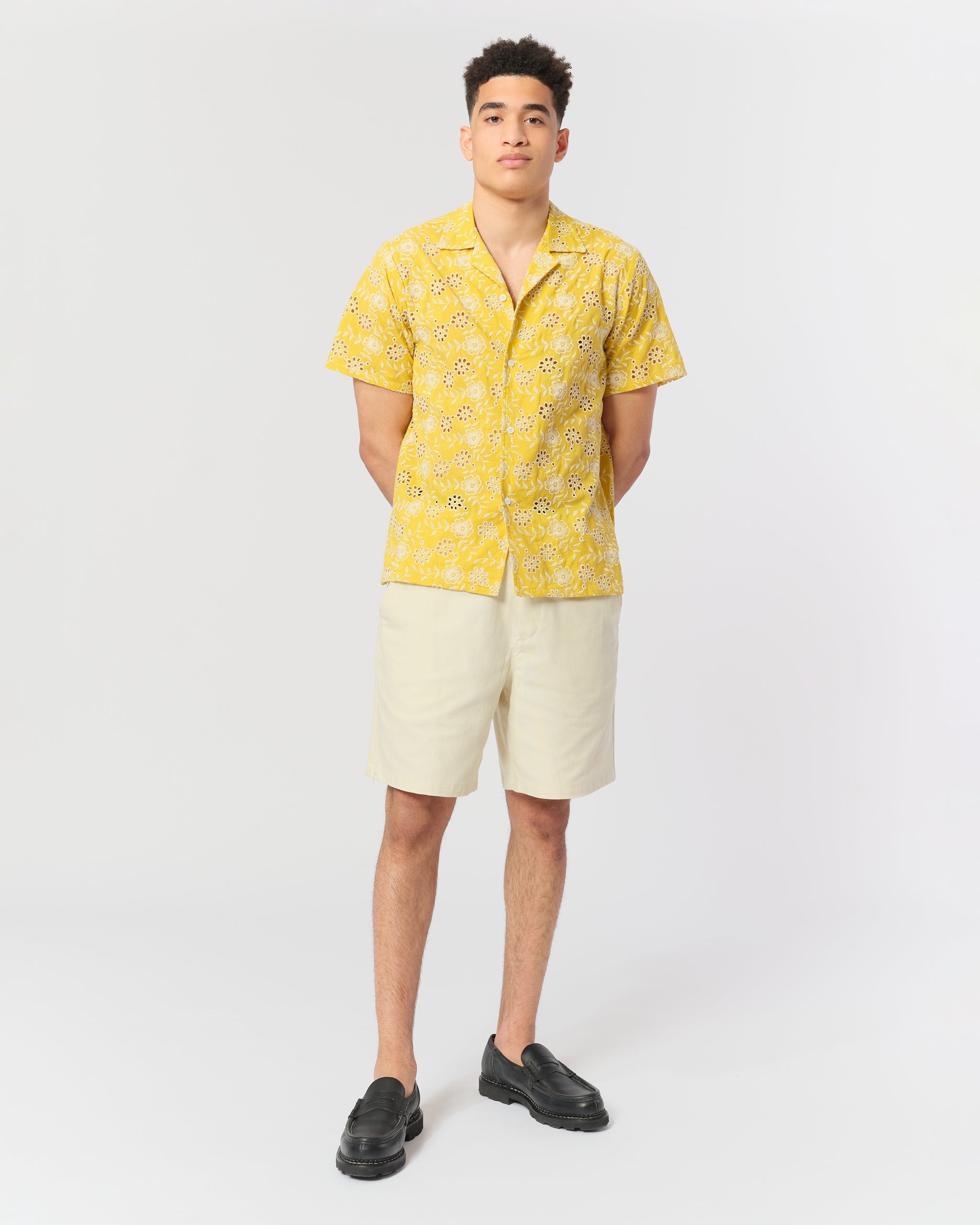 model wearing Yellow camp shirt with an embroidered floral pattern
