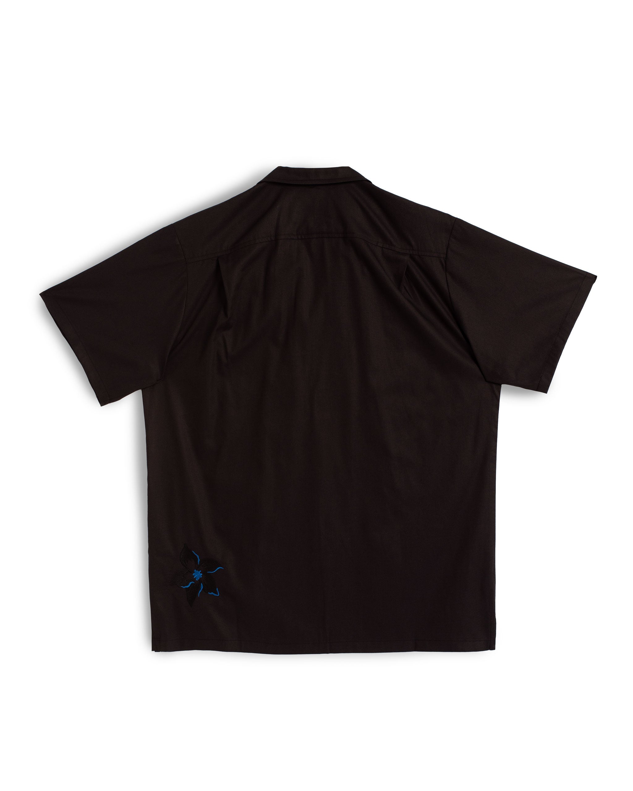 Back view of the Bather Men's Black Embroidered Lily Camp Shirt, showcasing the white embroidered lily floral motifs and the relaxed, straight-hem silhouette.