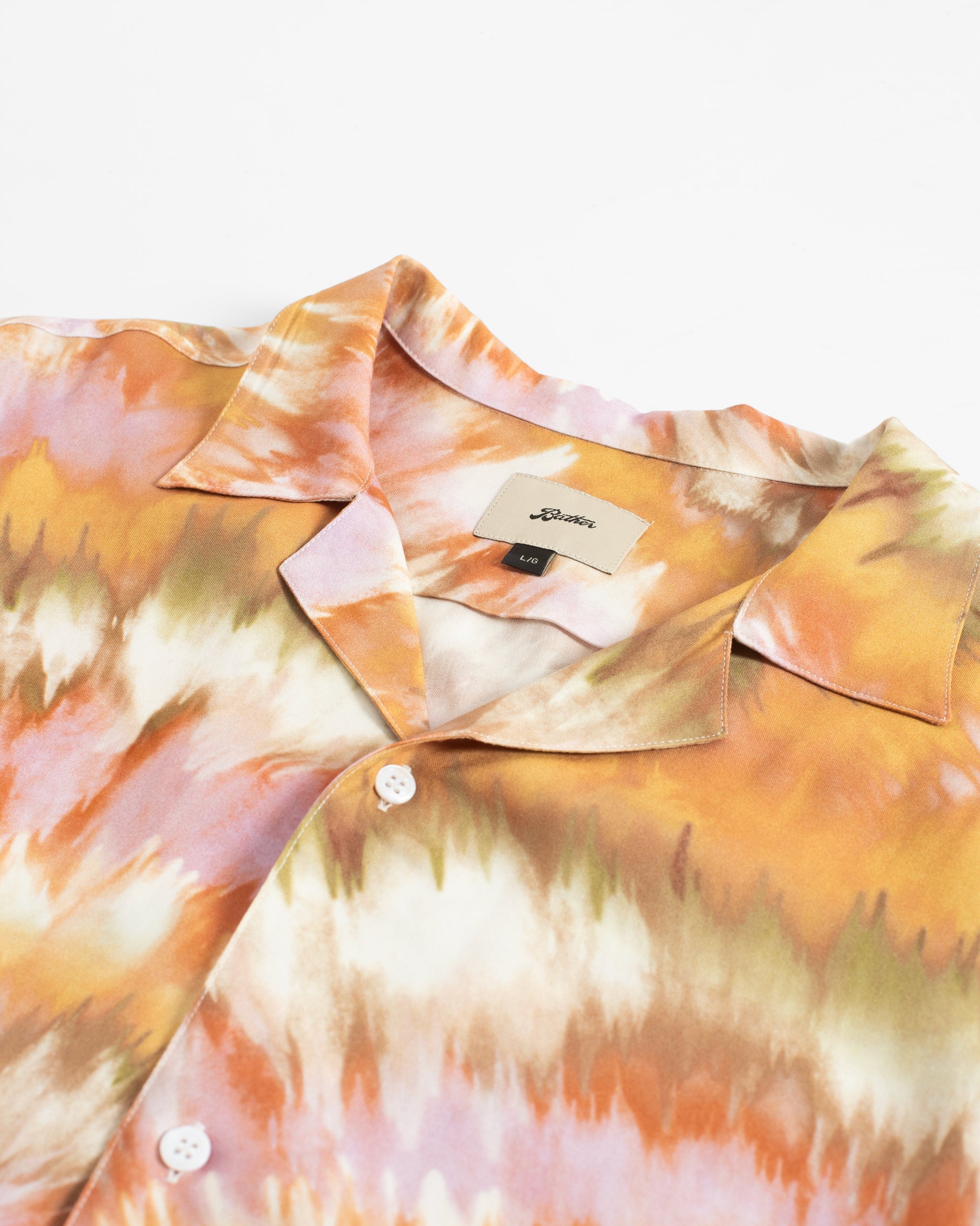 Close-up of the silky 100% rayon fabric on the Bather Men's Calypso Swirl Camp Shirt showing the intricate pleated tie-dye pattern.