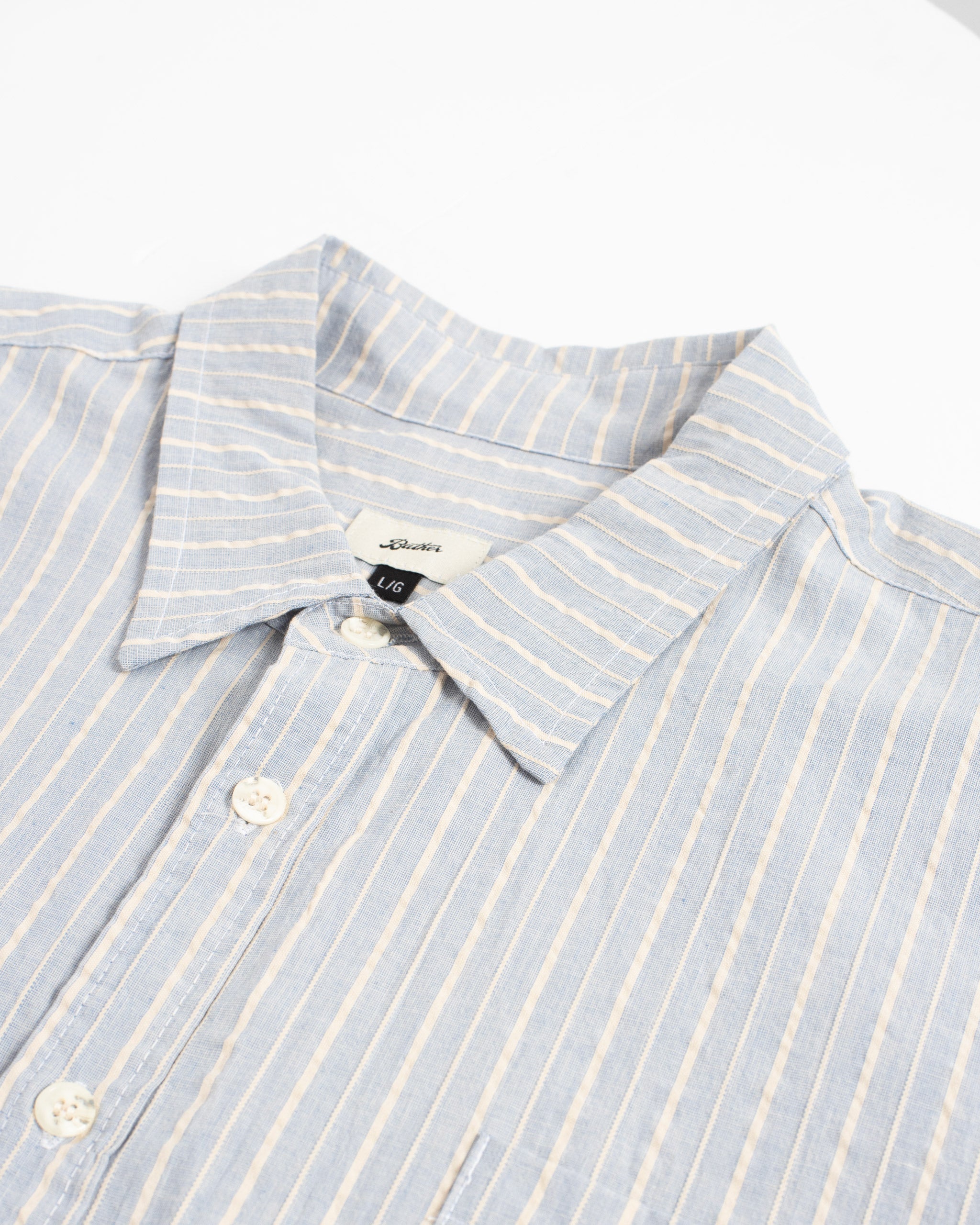 Close-up of light blue and white striped button-up shirt with collar and buttons