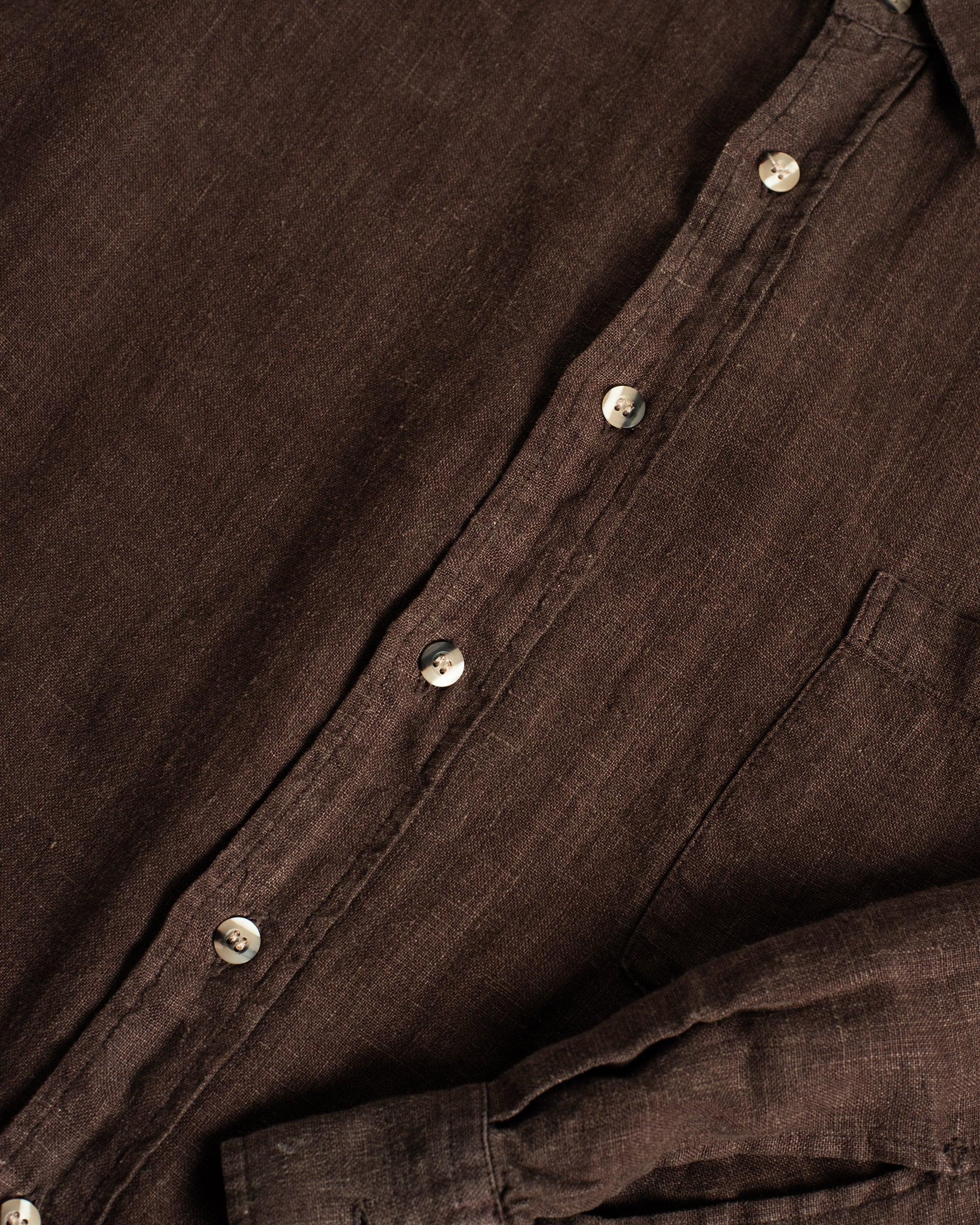 Detailed close-up of the Bather Men's Espresso Linen Leisure Shirt highlighting the natural texture and high-quality stitching of the deep brown linen.