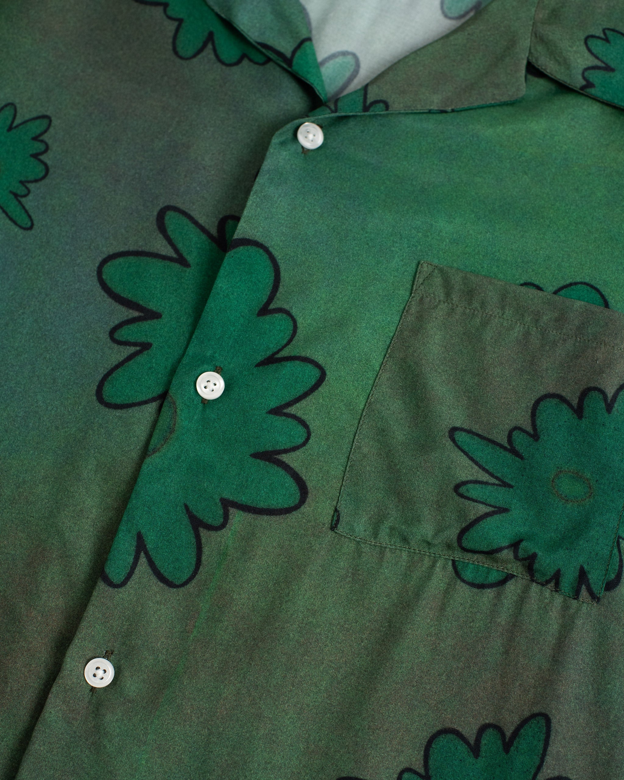 Detailed view of the floral pattern and buttons on the Bather Men's long-sleeve camp shirt.