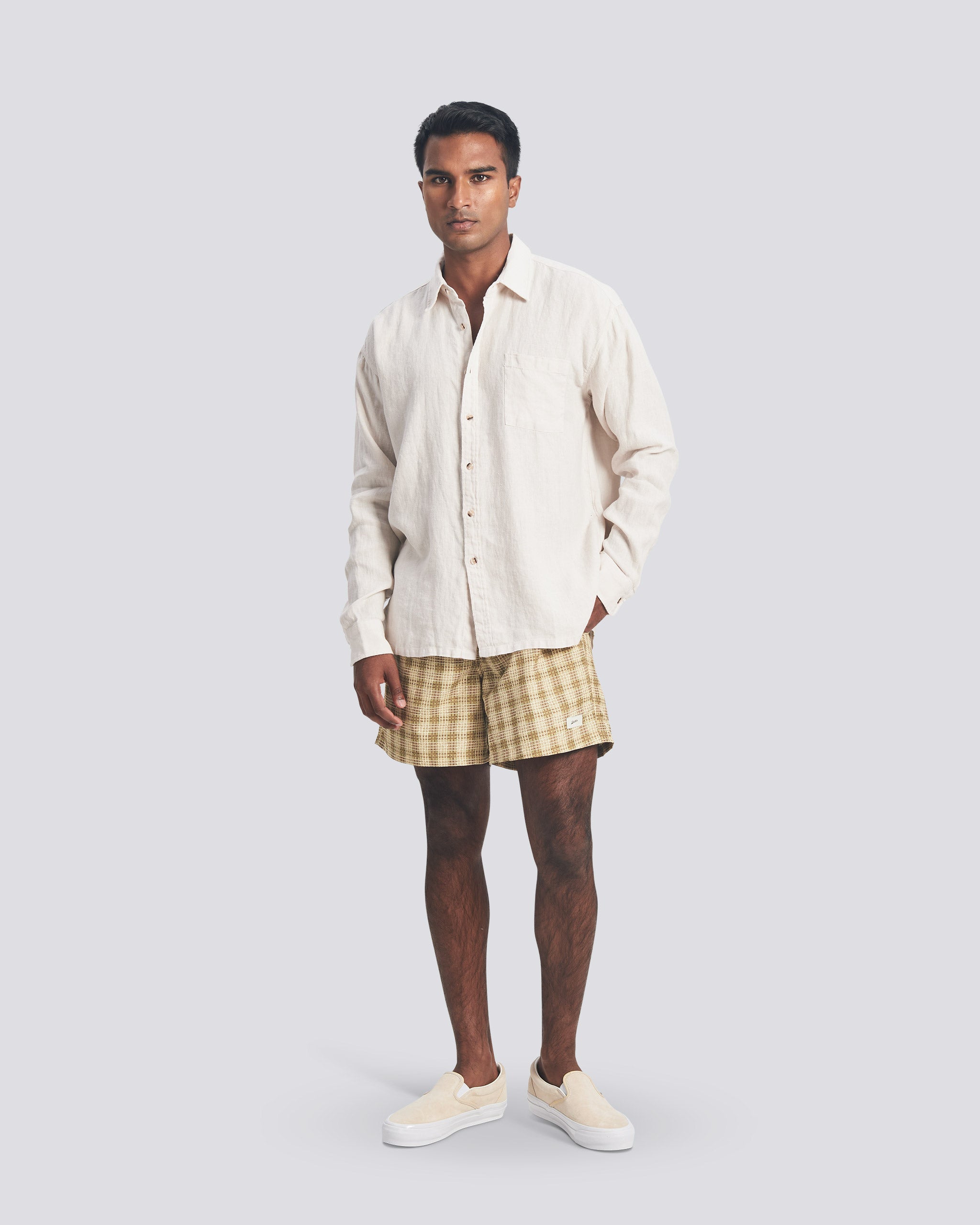 Bather Men's Pearl Linen Leisure Shirt in off-white, styled with checkered swim trunks and cream slip-on shoes on a model.