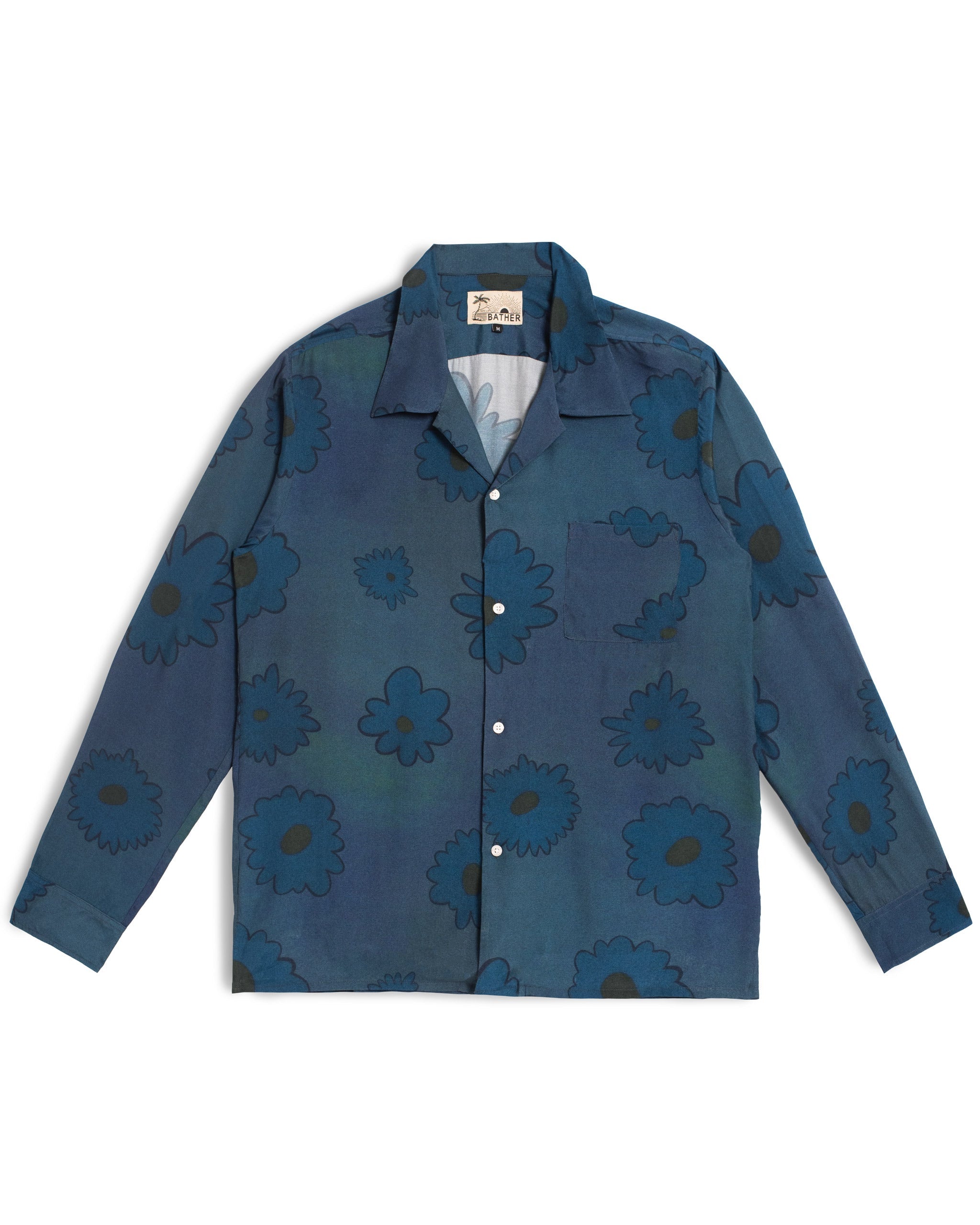 Bather Men’s Sapphire Bloomscape Long Sleeve Camp Shirt featuring a dark blue and white floral pattern, a single chest pocket, and an open collar on a white background.