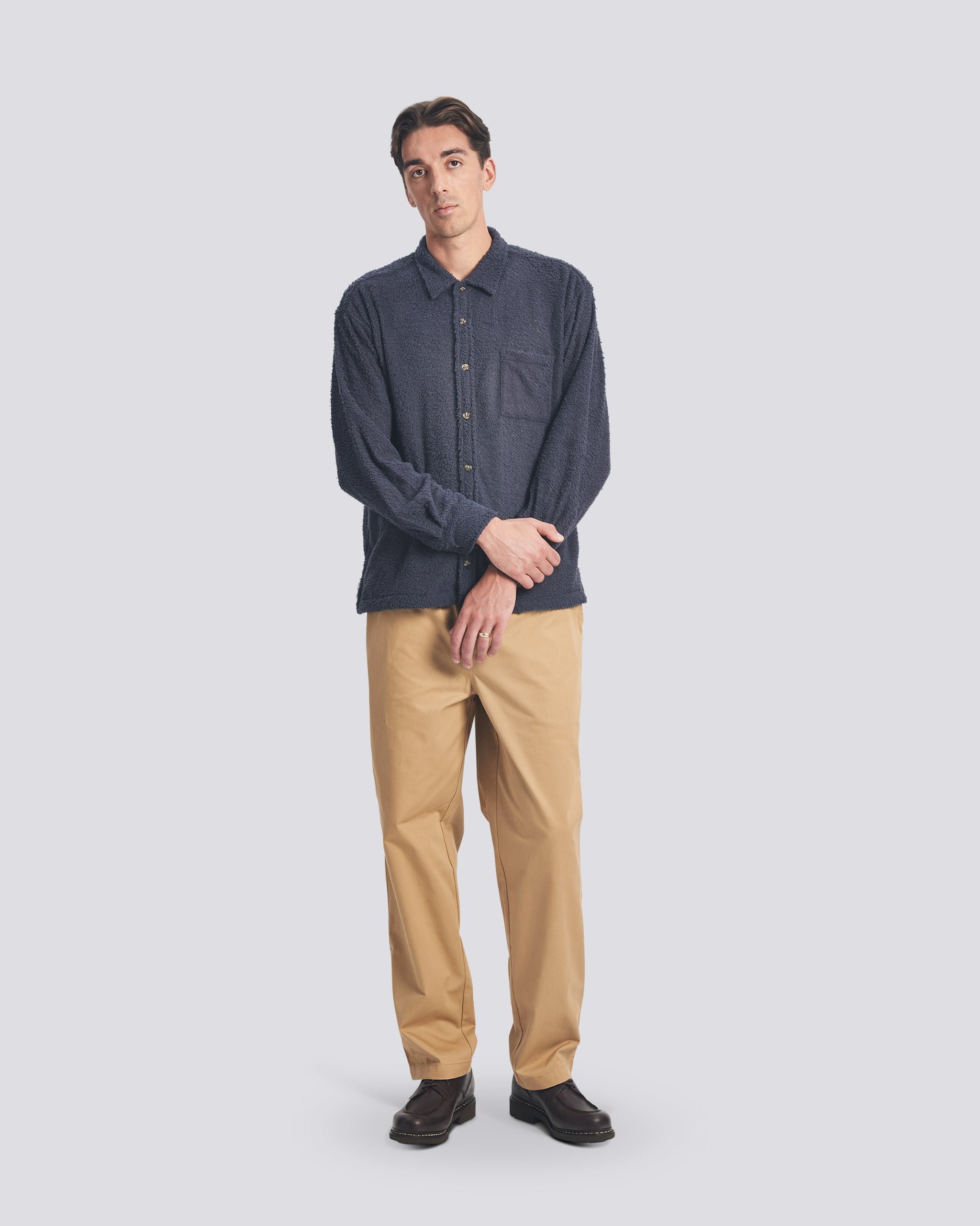 Bather Men’s Whale Shaggy Leisure Shirt in dark navy blue, styled buttoned up with tan chinos and black leather shoes on a model.