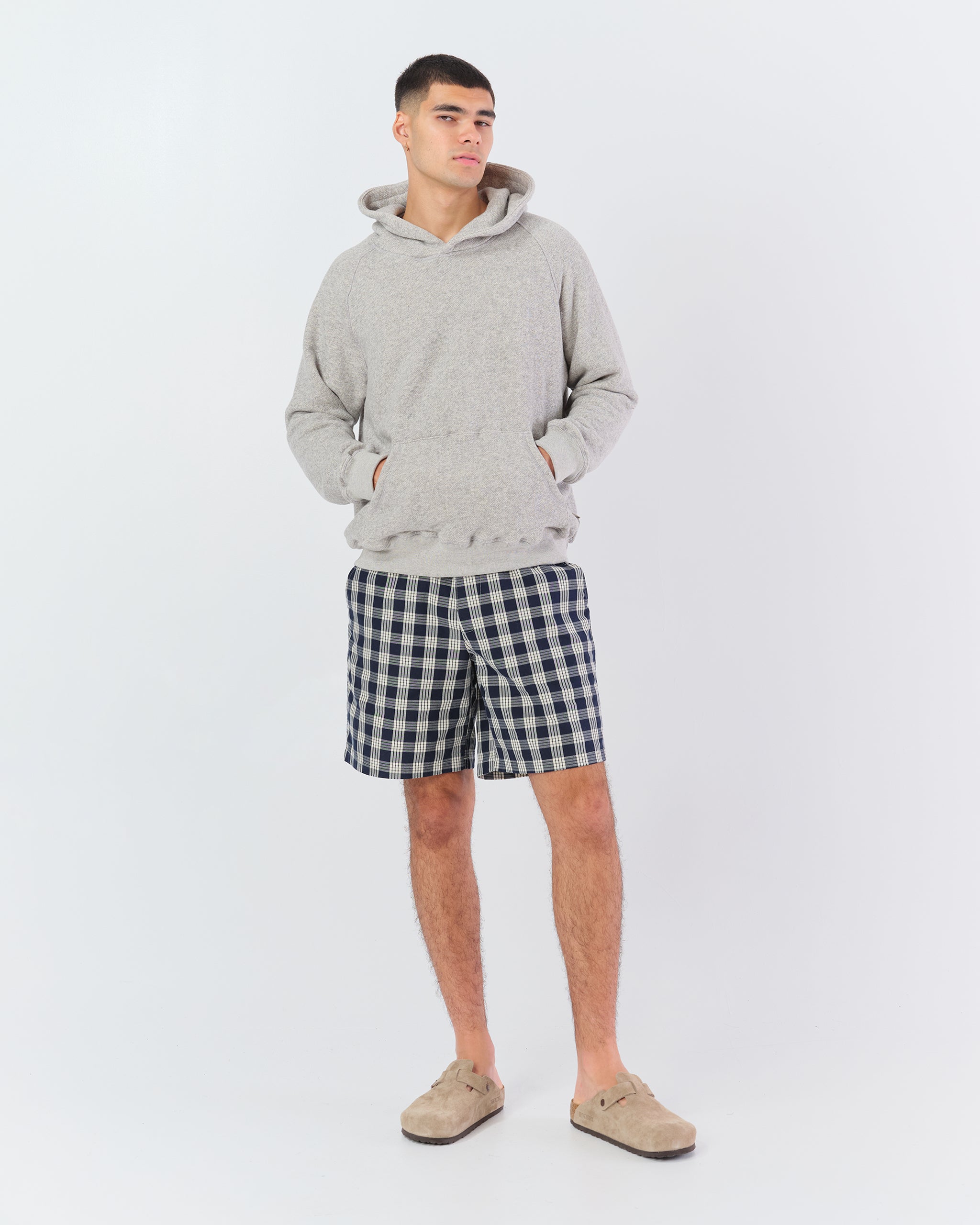 Bather Men's navy plaid short on model wearing grey Bather hoodie on white background