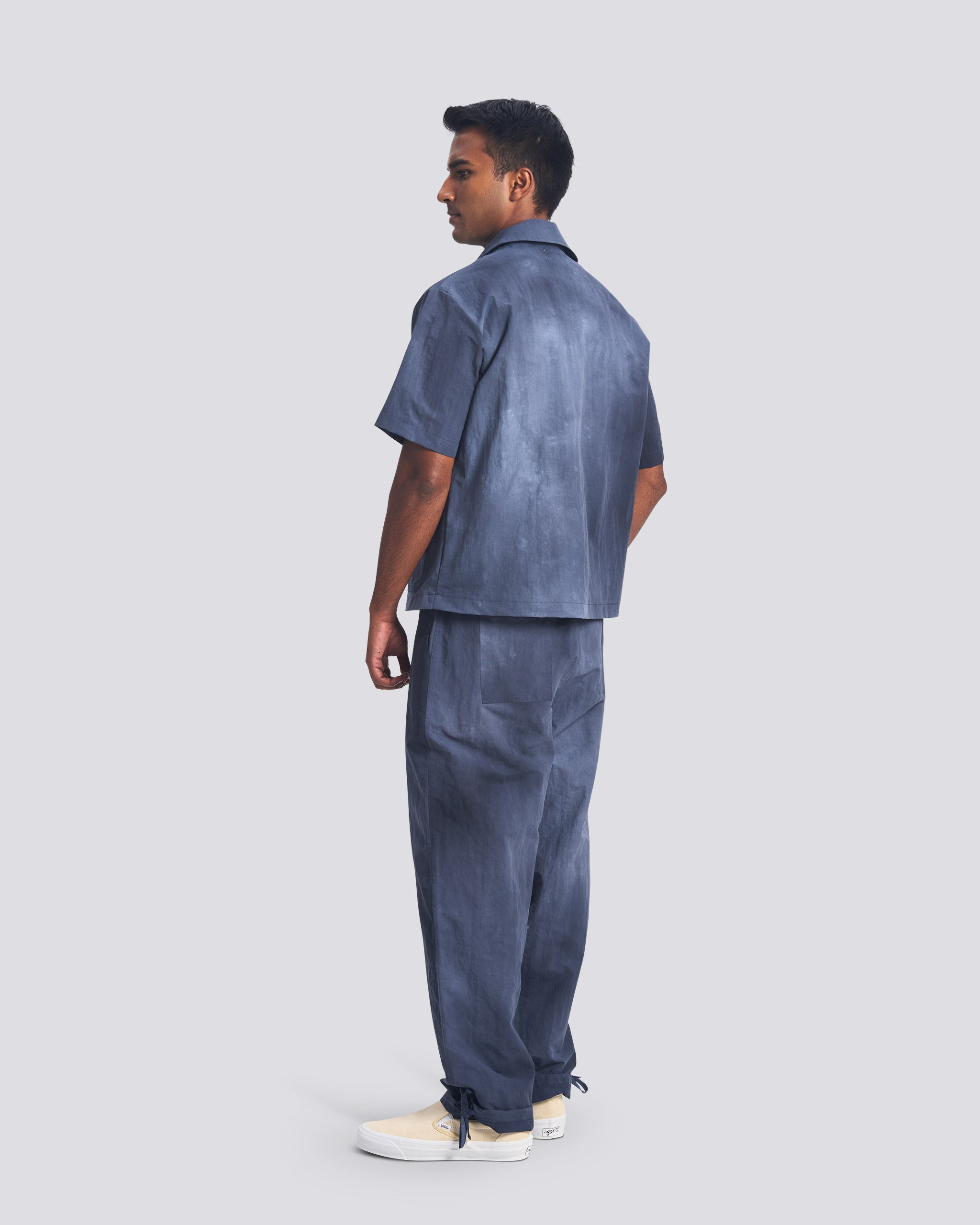 Bather men's navy over dyed nylon pant and zip top on grey background worn by model