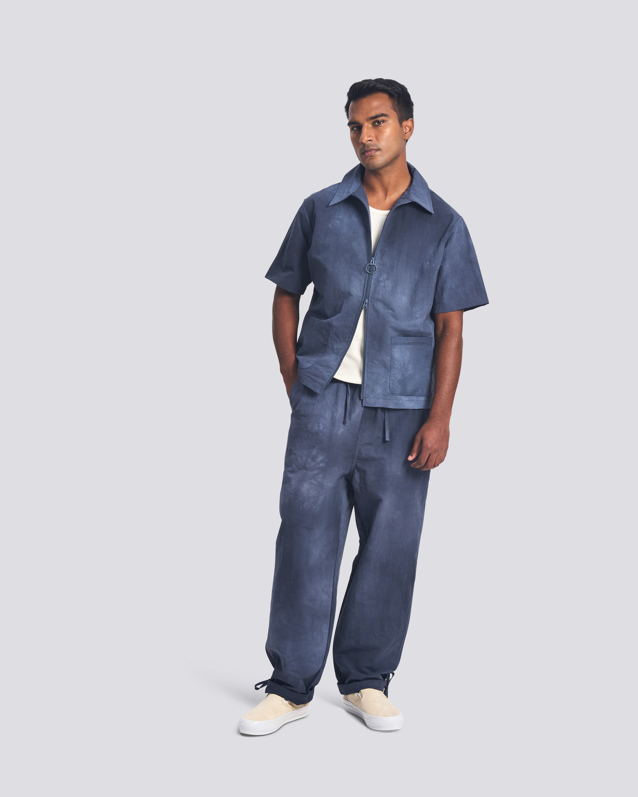 Bather men's navy over dyed nylon pant and zip top on grey background worn by model