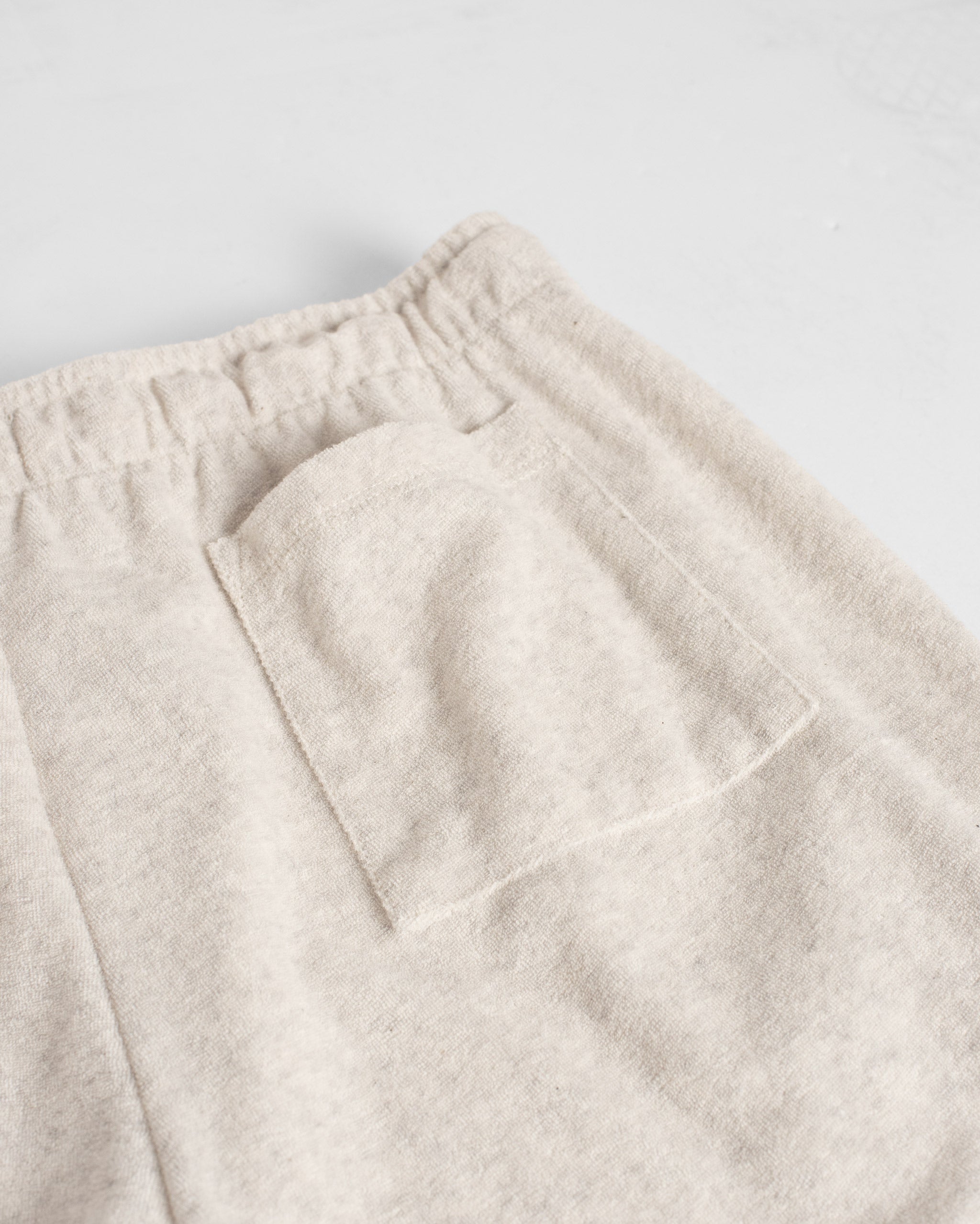 Closeup detail of back patch pocket on Bather men's cream towel terry shorts with drawstring