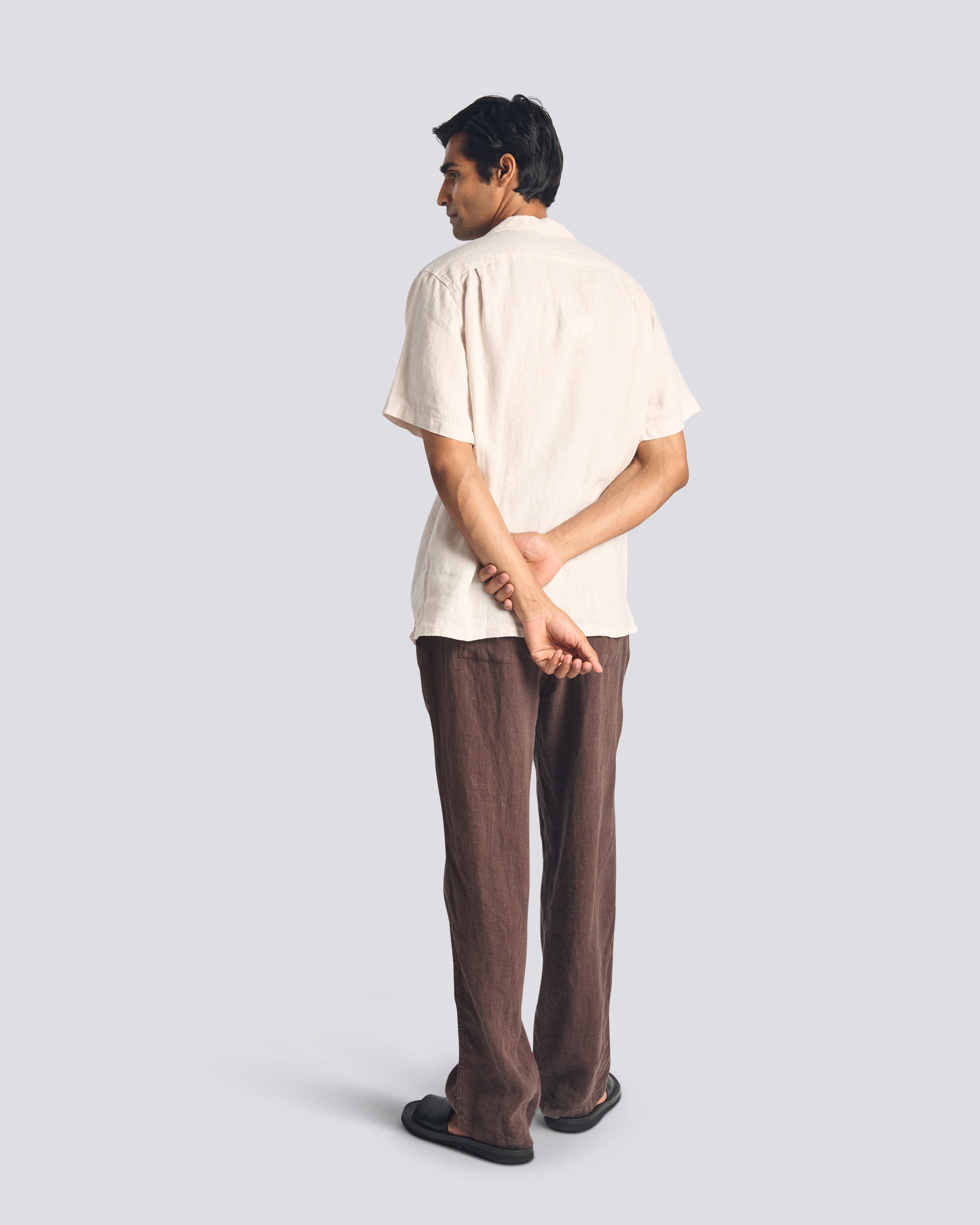 Back view of model wearing Bather men's dark brown linen pant