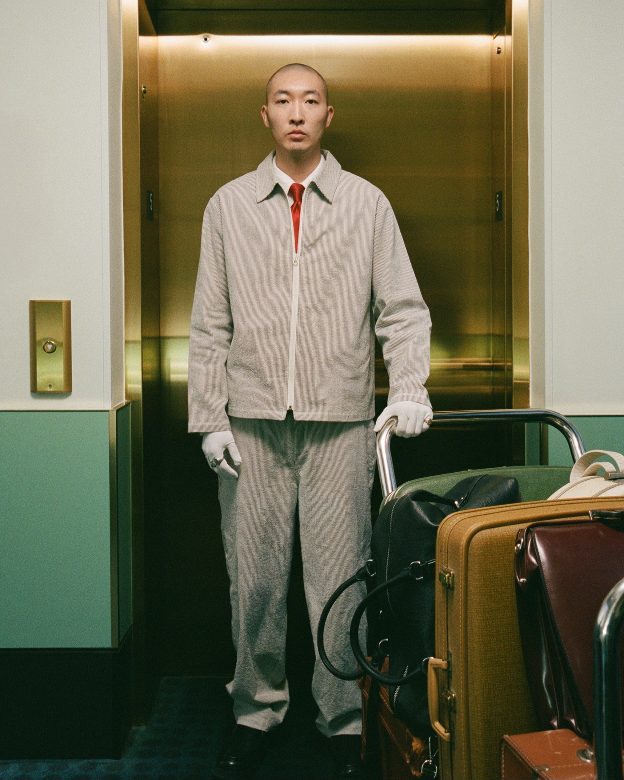 Model wearing Bather men's brown pinstripe pant and jacket in a hotel