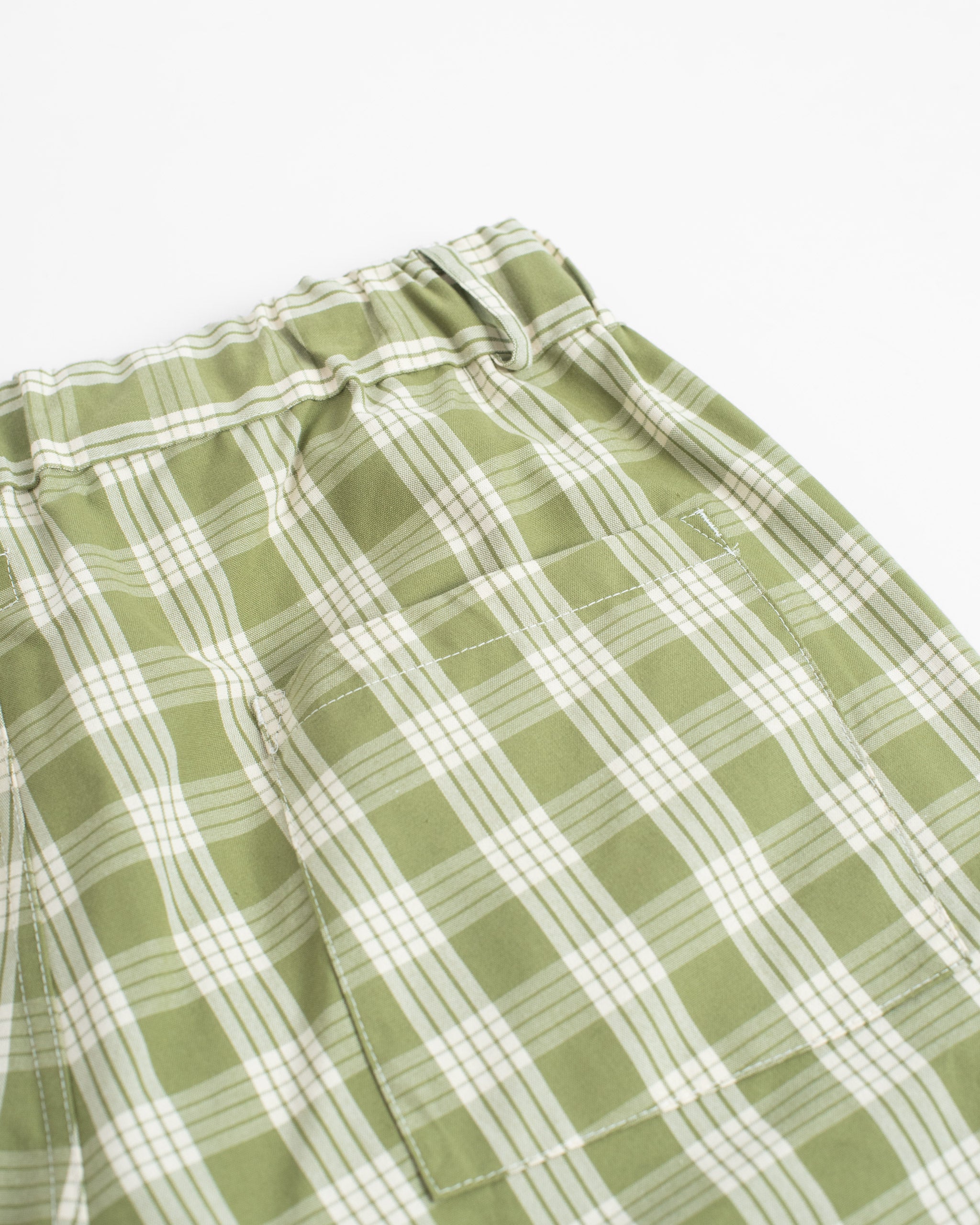 Closeup shot of back patch pocket on Bather men's green check shorts