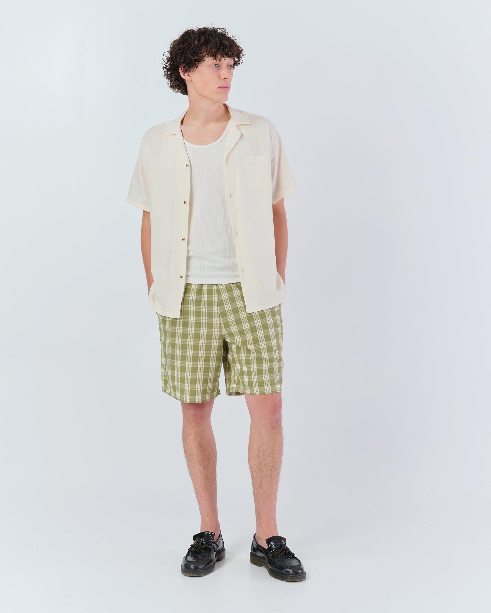 Model wearing Bather men's green check shorts from the front on white background