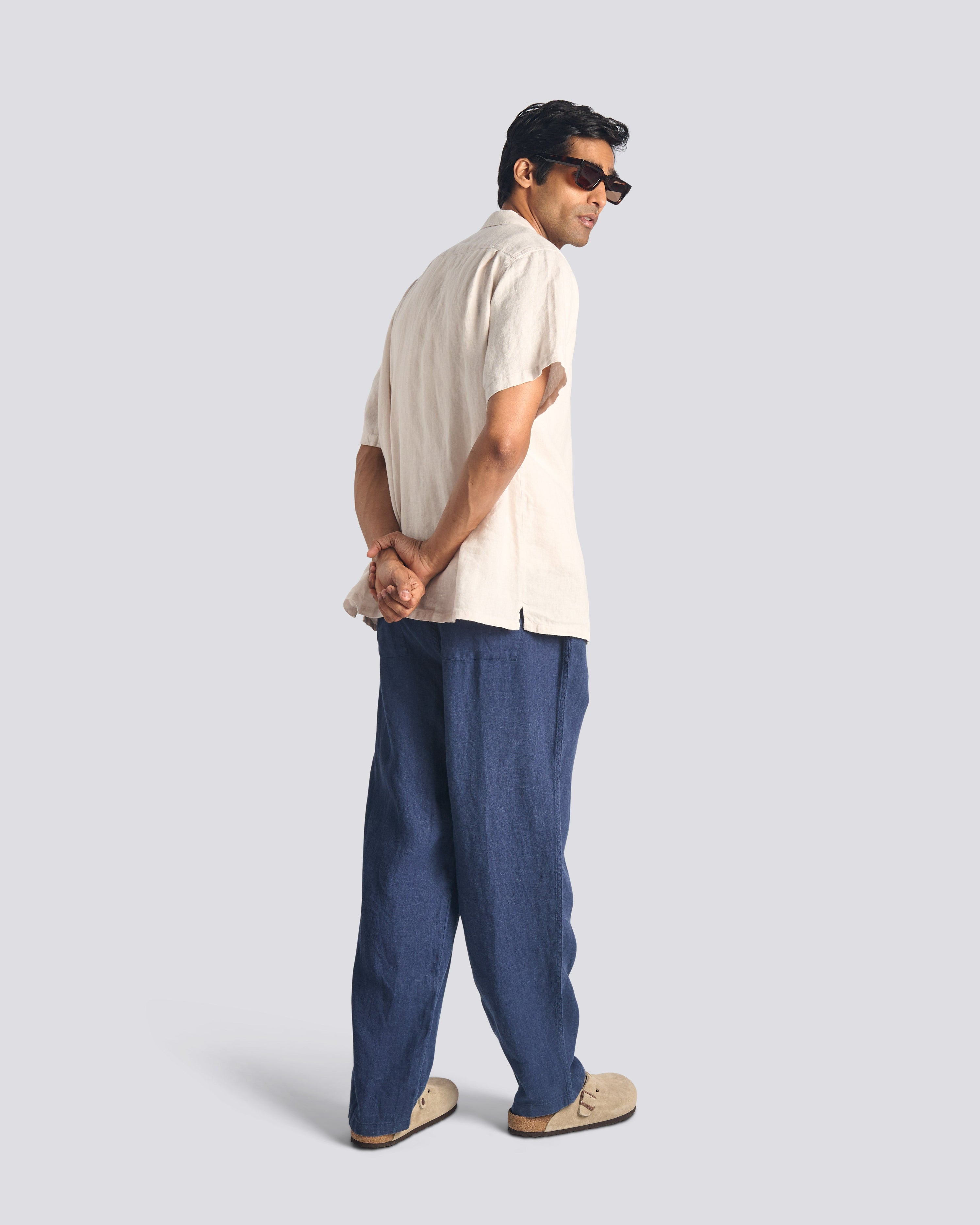 Back view of model wearing Bather men's navy linen pant