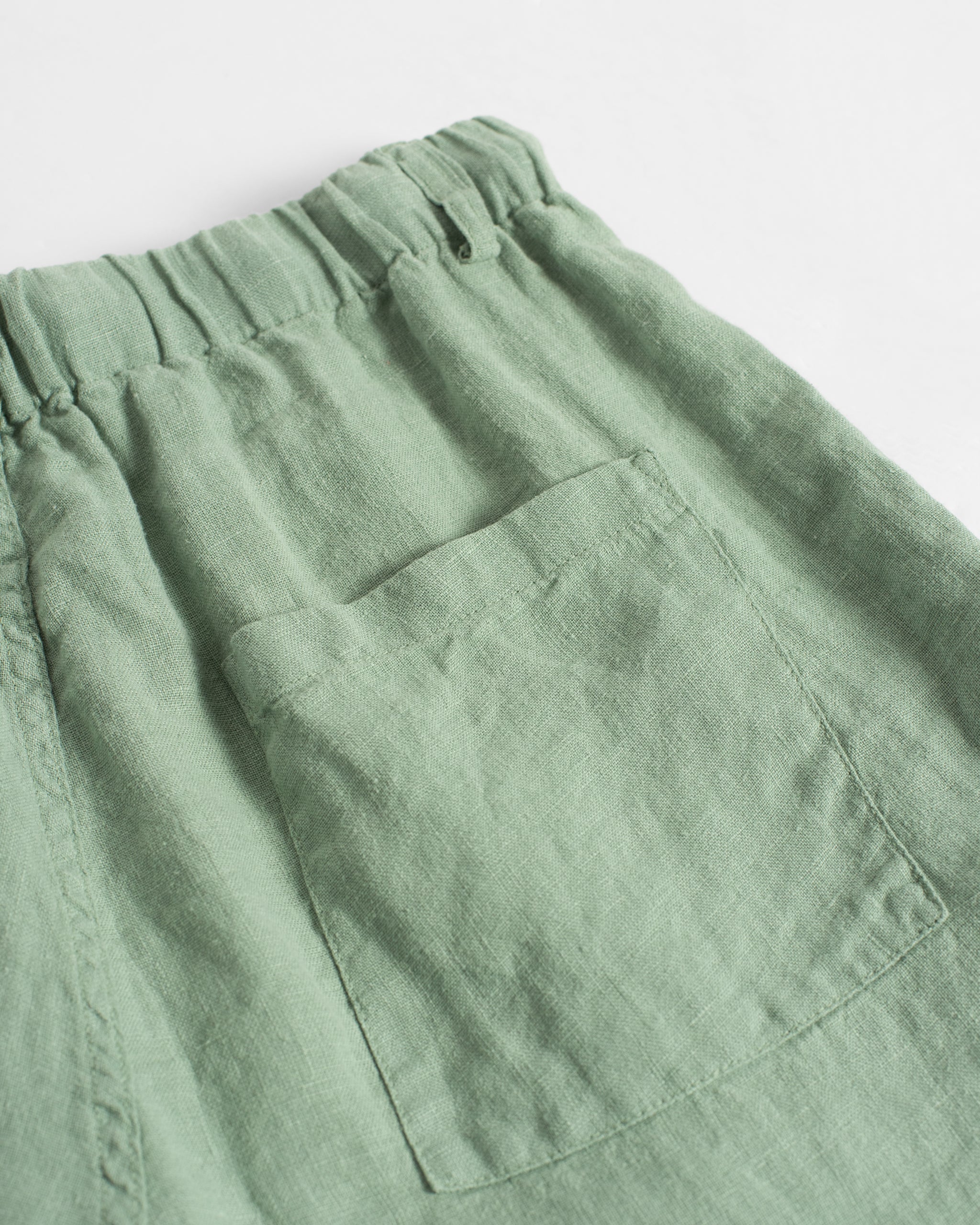 Closeup of back pocket on Bather men's light green linen shorts
