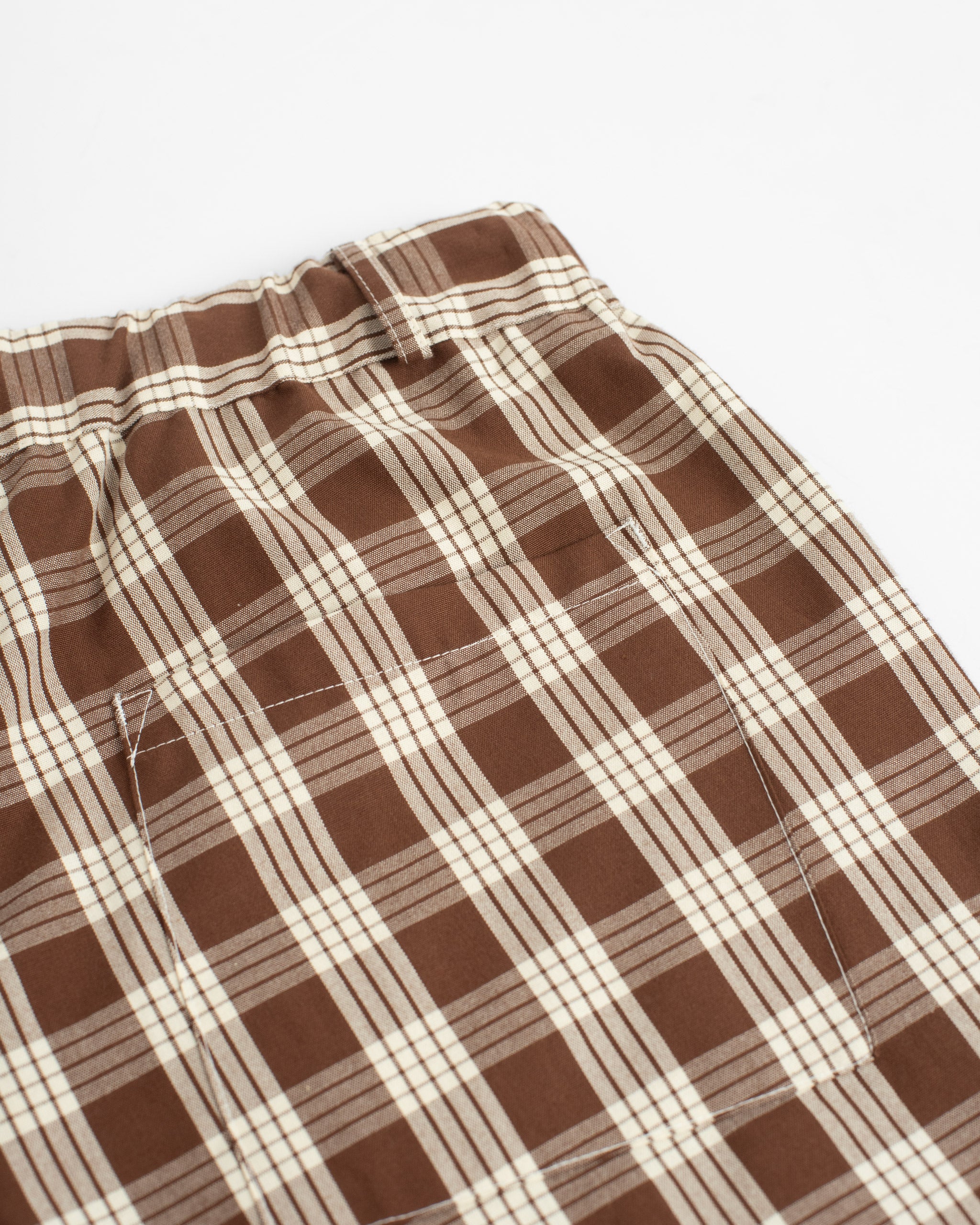 Closeup detail of back pocket on Bather men's brown check shorts