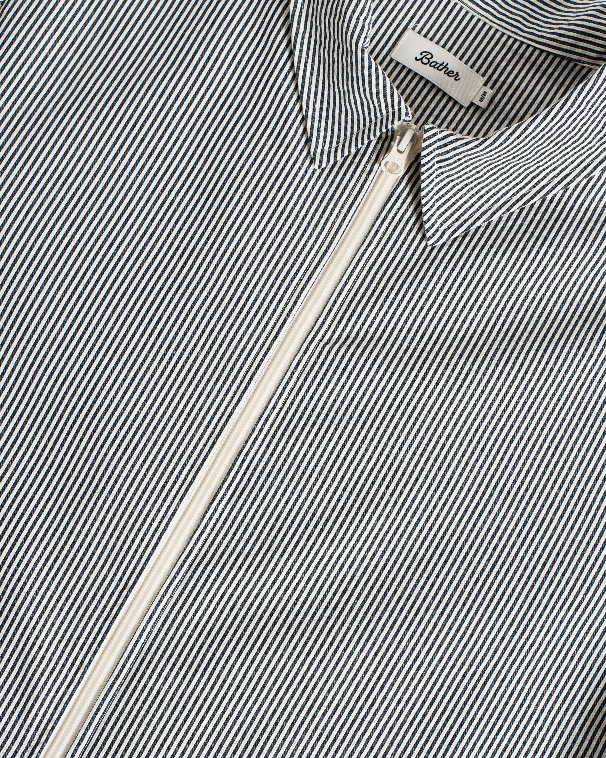 Close up of Bather navy pinstripe tour jacket in Japanese cotton pinstripe fabric featuring a two way front zipper and collar