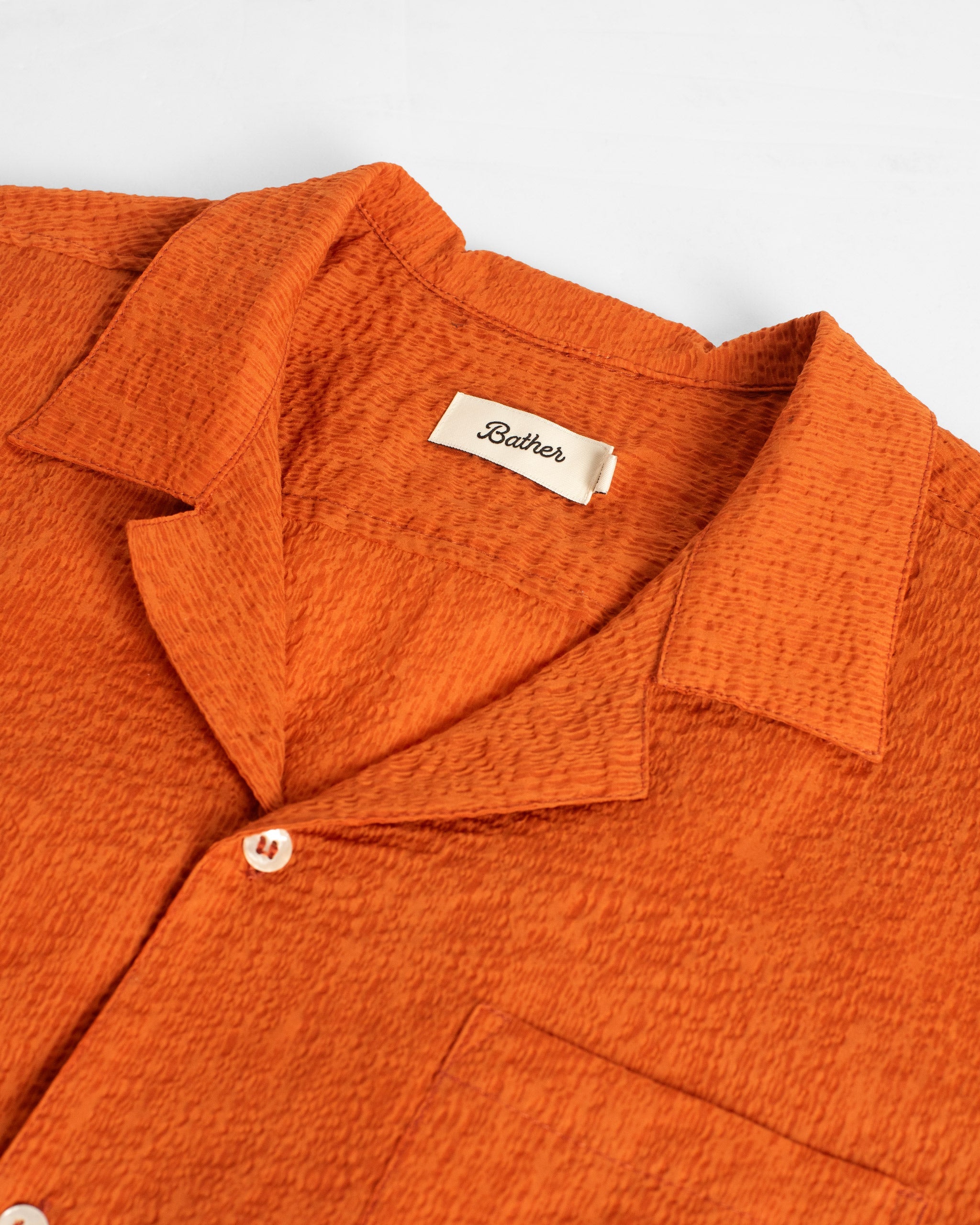 Detailed close-up of the Bather Men's Cantaloupe Ripple Leisure Shirt showing the 100% organic cotton dobby fabric and intricate tonal stitching.