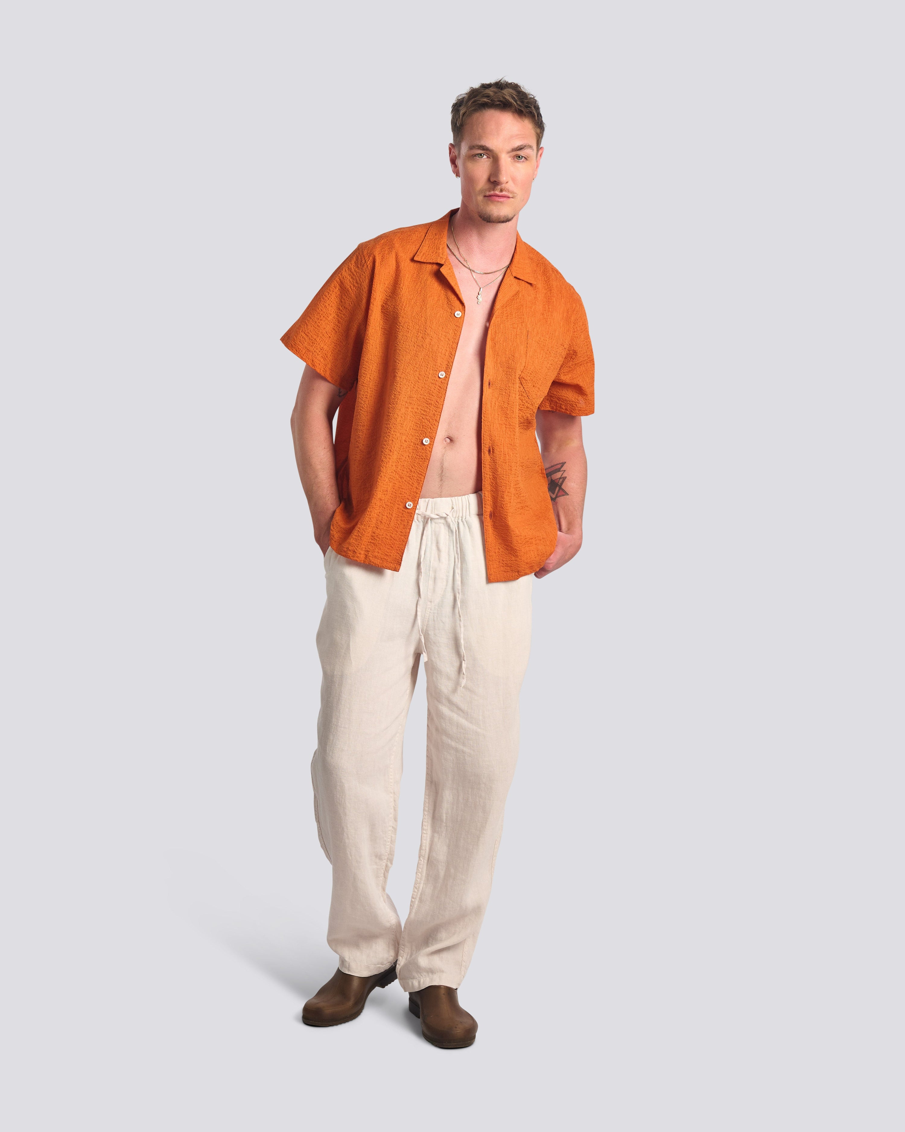 Male model wearing the Bather Men's Cantaloupe Ripple Leisure Shirt styled for a relaxed, modern summer look.
