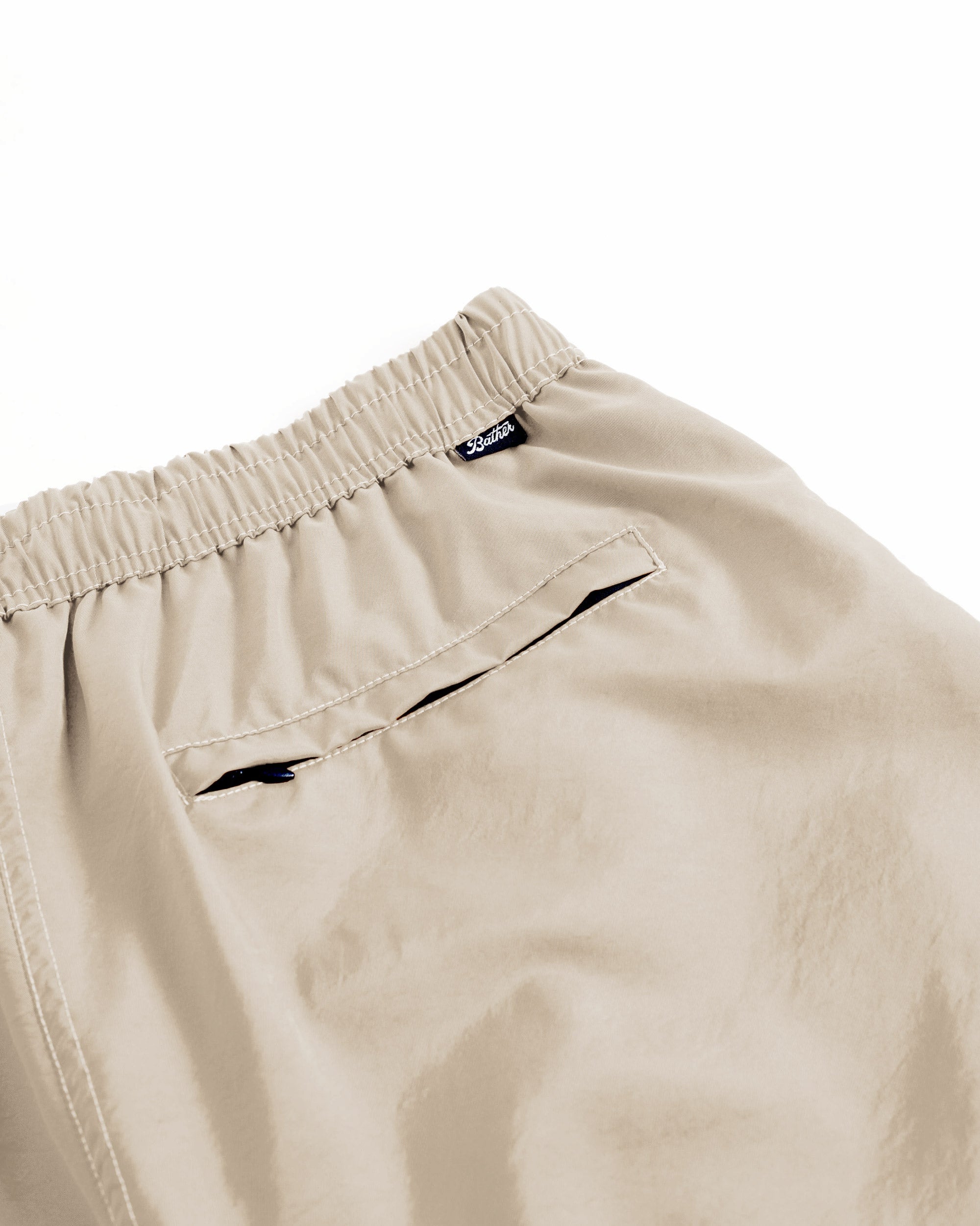 Close-up of mens shiny beige swim trunk with zipper closure pocket