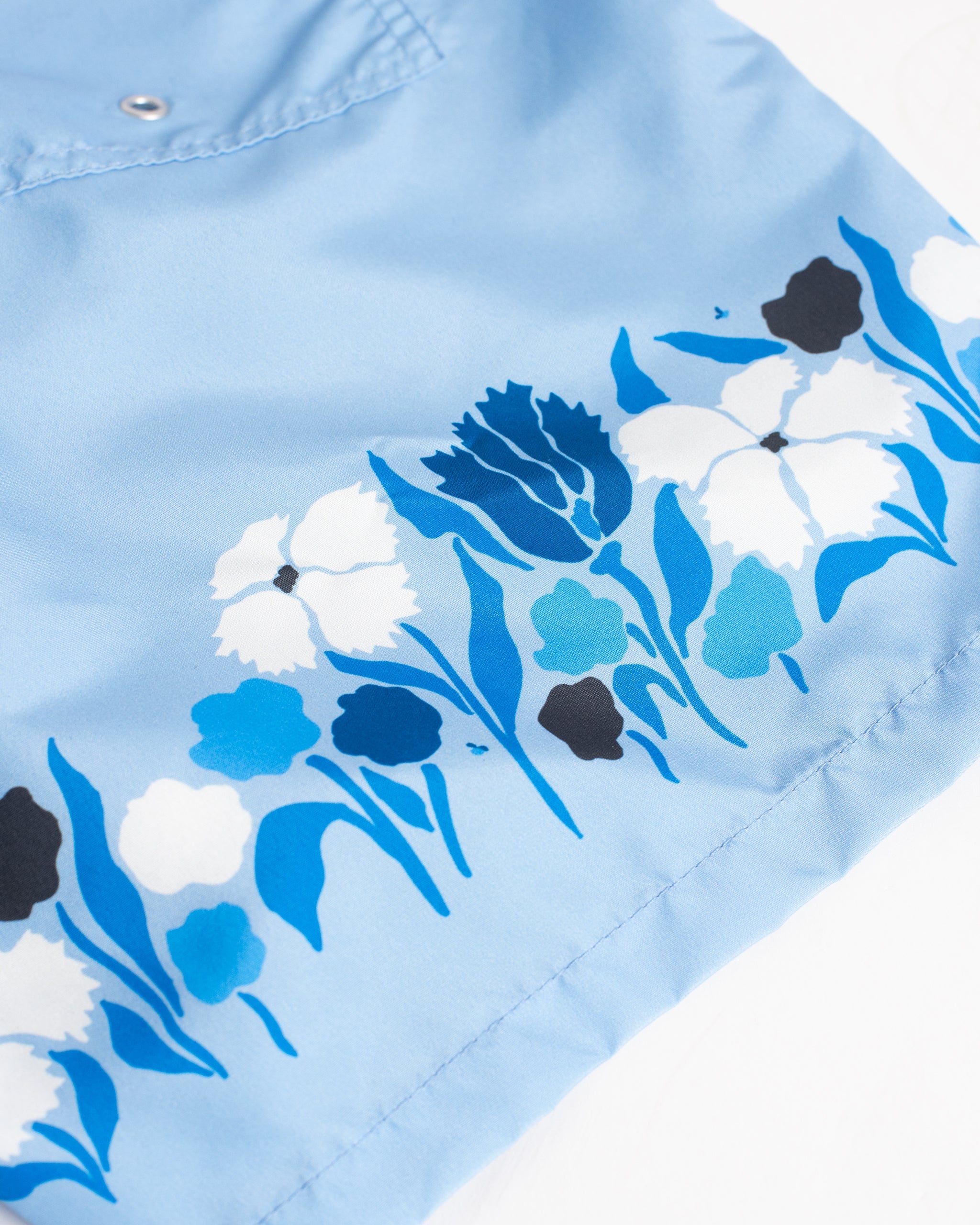 Men’s light blue swim trunks with floral border print and white drawstring 