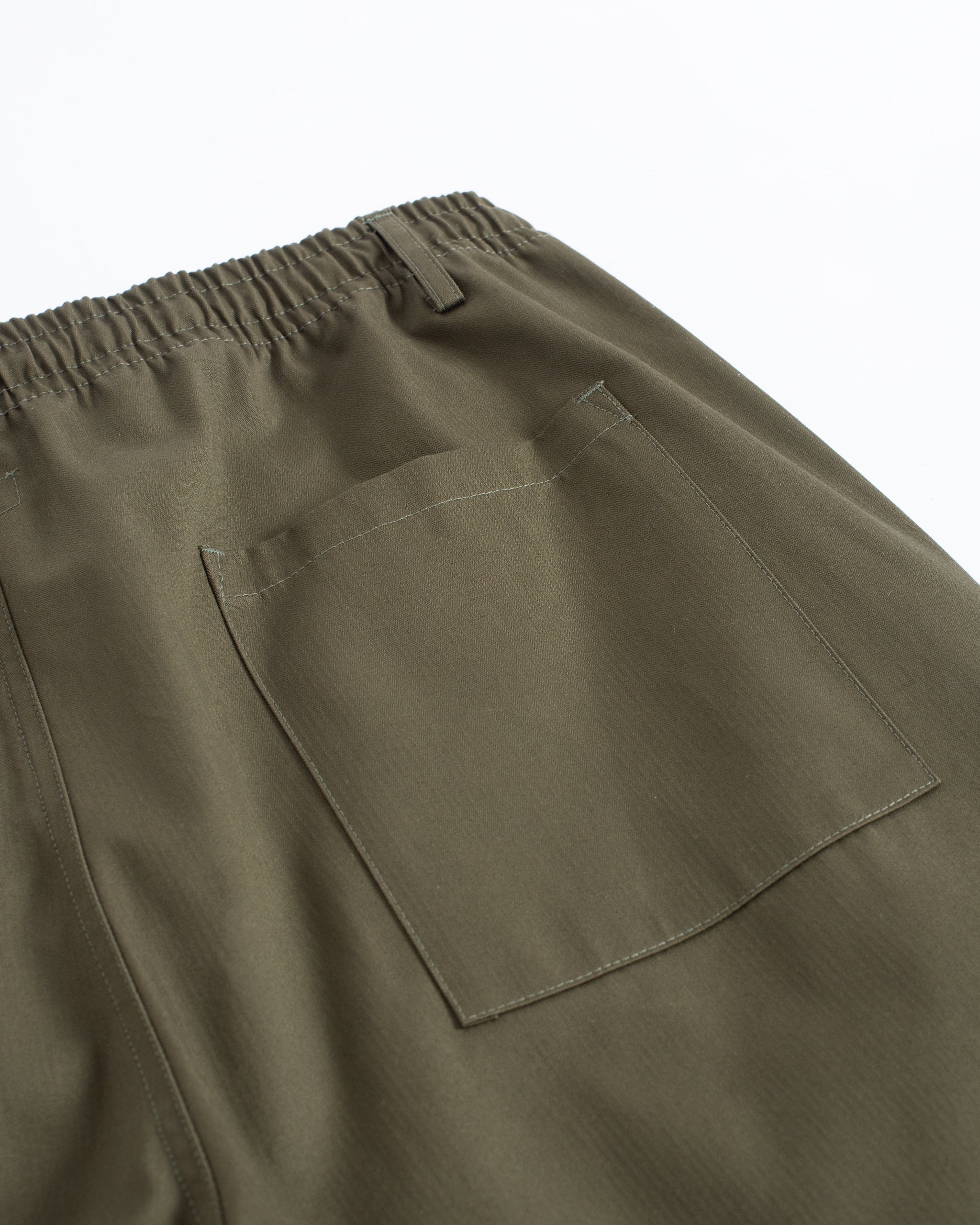 Close-up of back pocket on Bather men's olive green herringbone drawstring pants