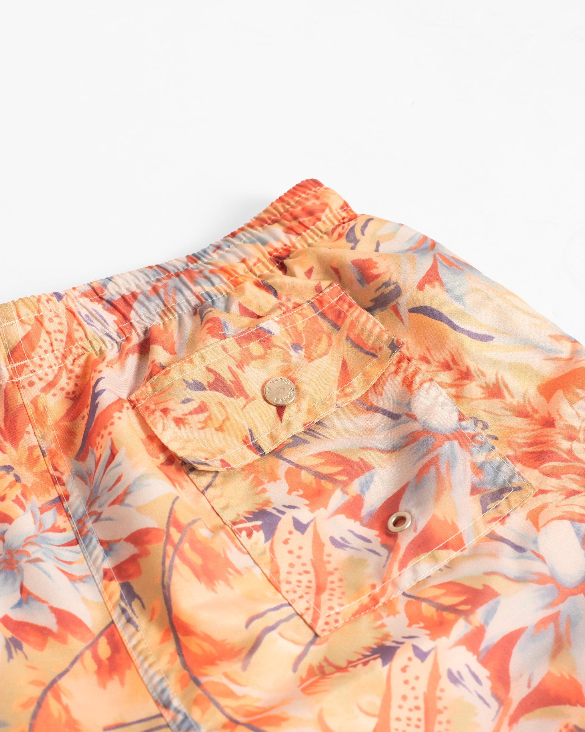 Close-up of a floral patterned shirt with orange and blue colors on a white background