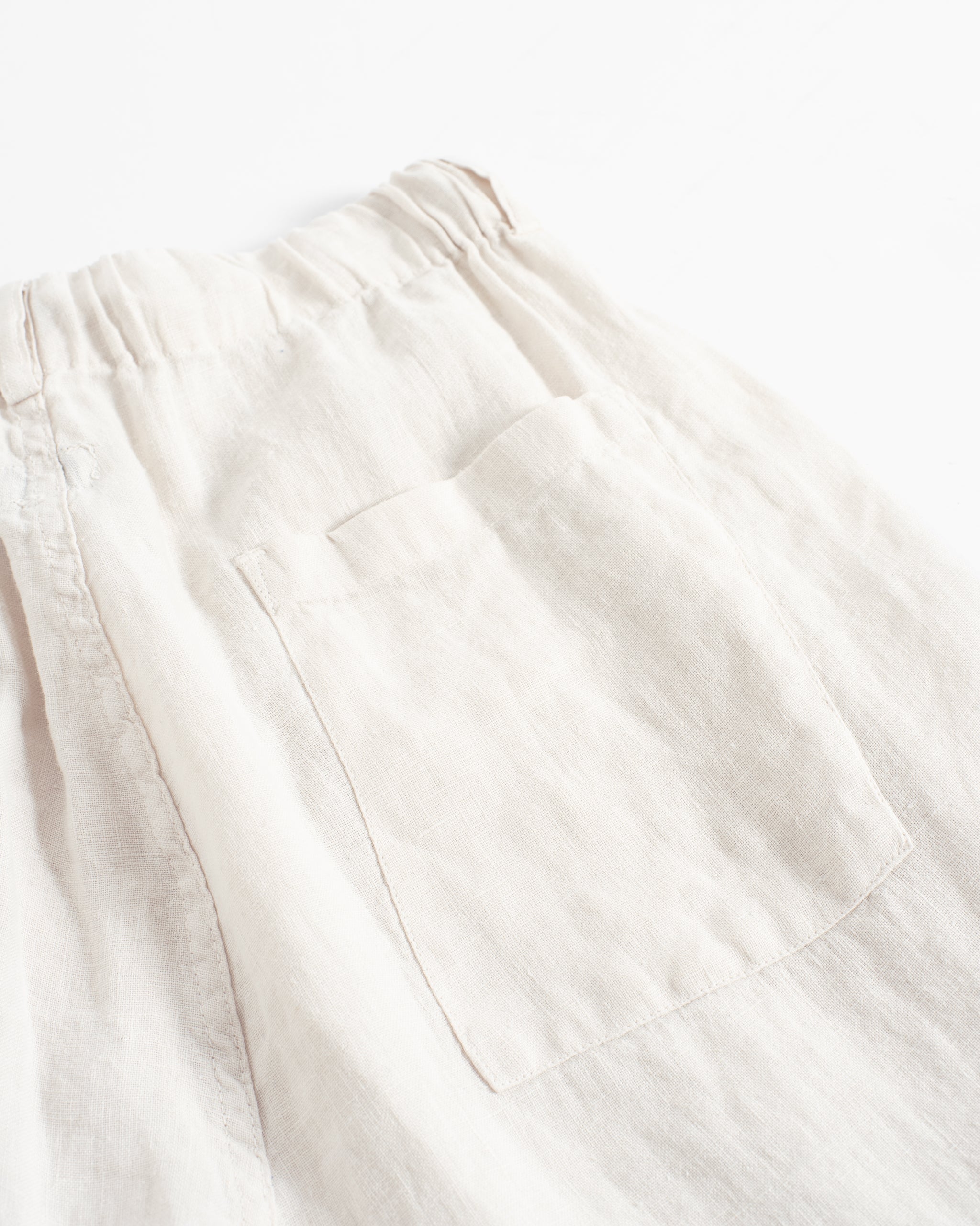 Closeup back pocket detail on the Bather men's off-white linen drawstring pant
