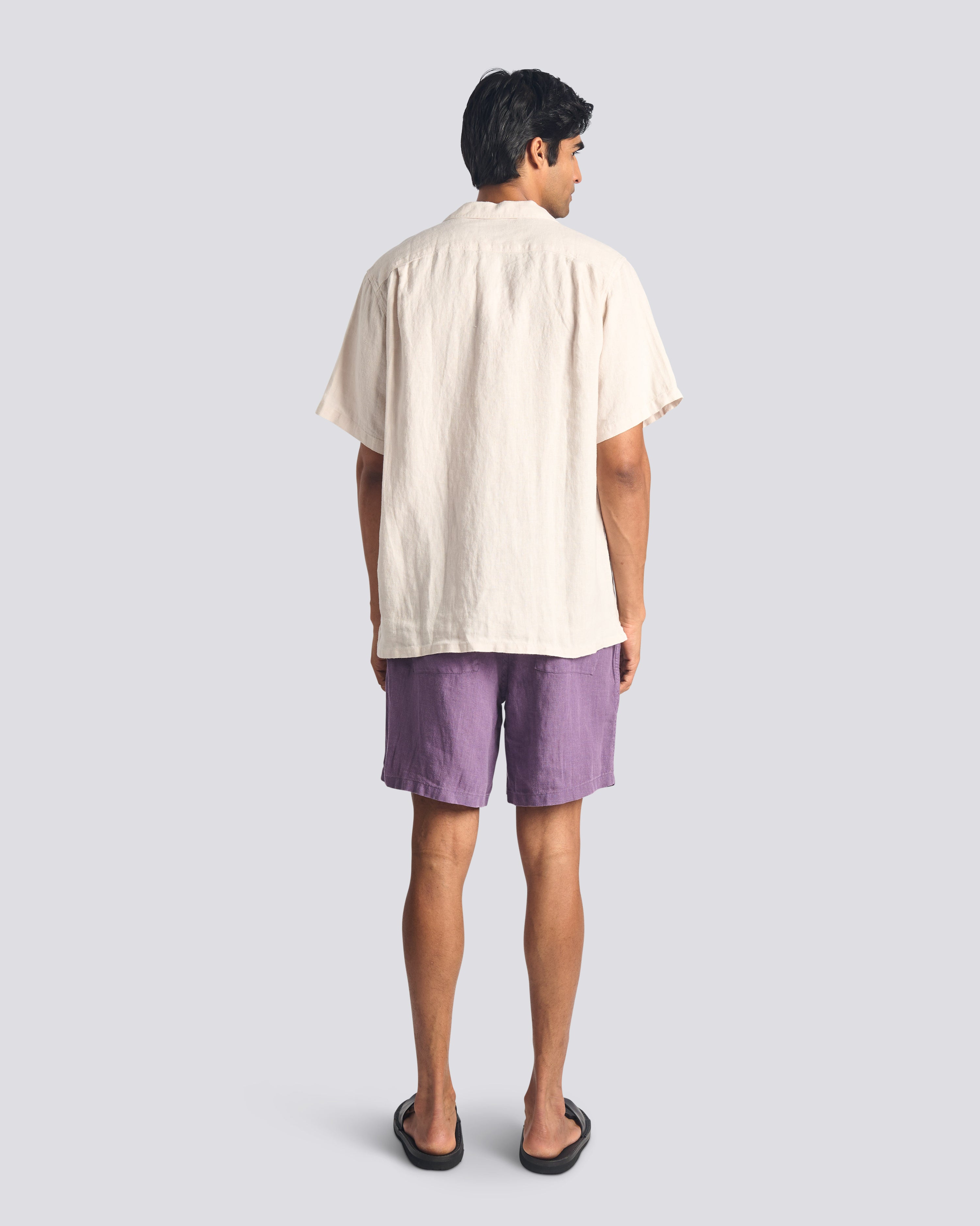 Model wearing Bather men's purple linen shorts with drawstring from the back on a white background