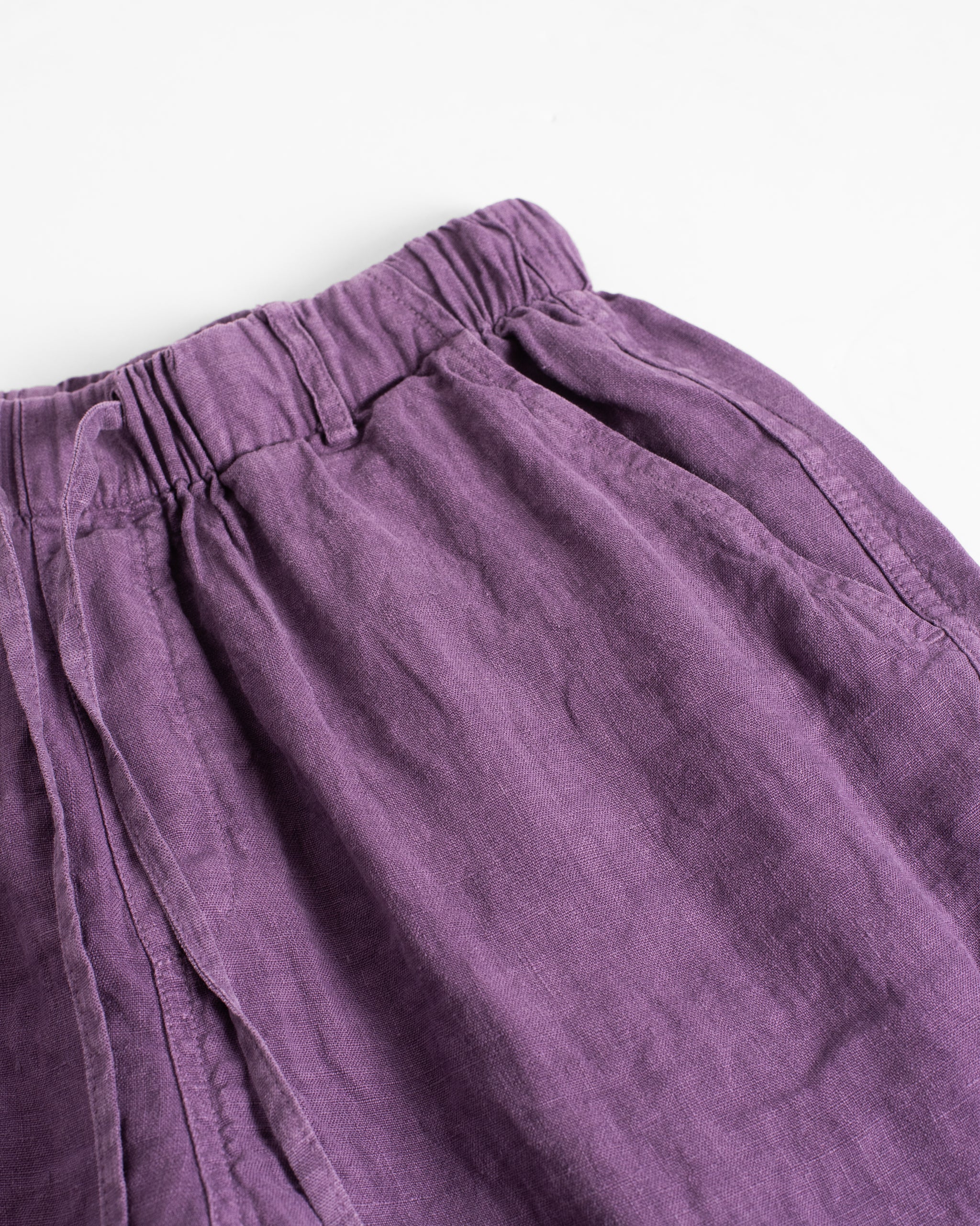 Closeup detail of the waistband and side pocket on the Bather men's purple linen short