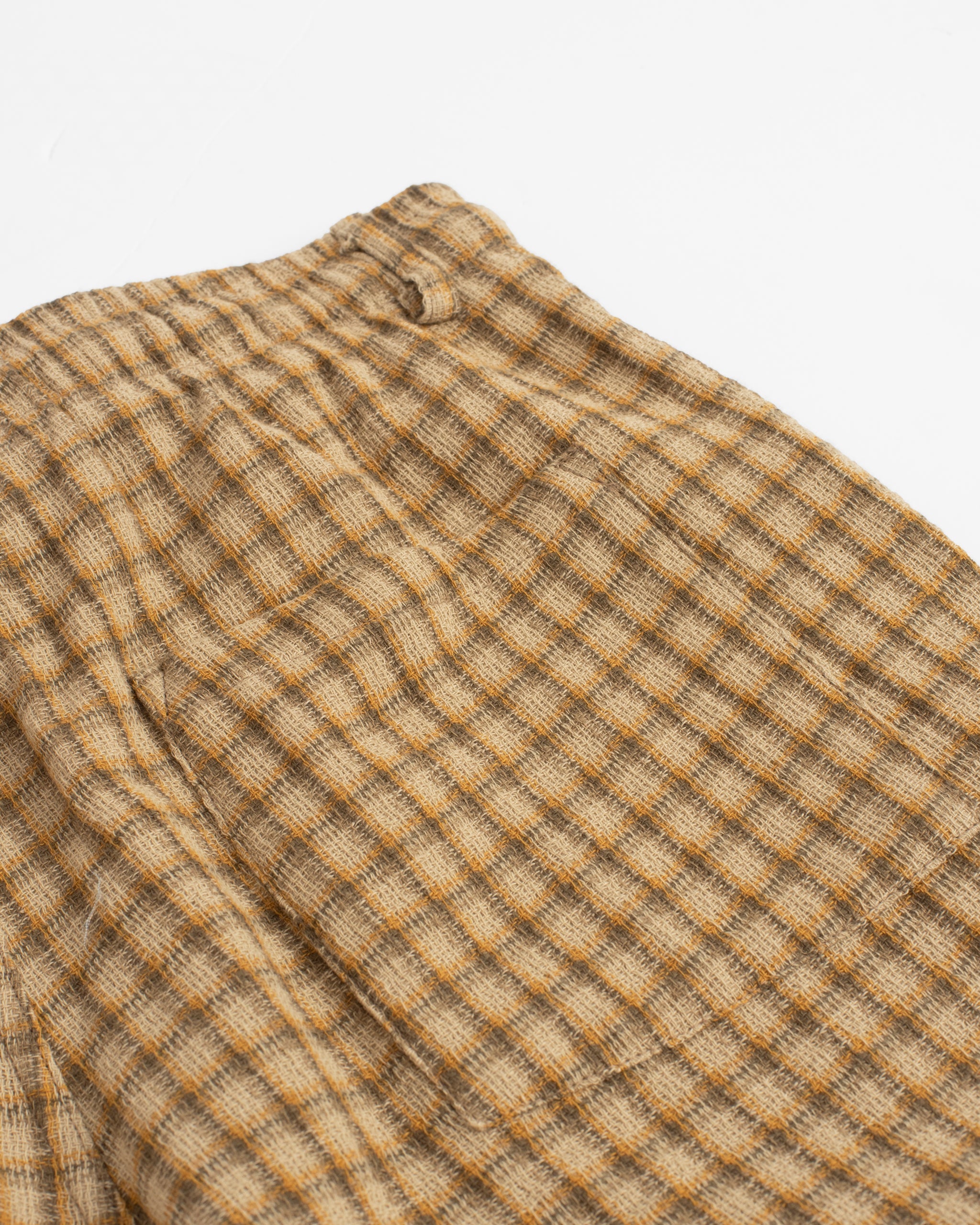 Close-up of back pocket on Bather men's brown drawstring shorts with checker plaid pattern