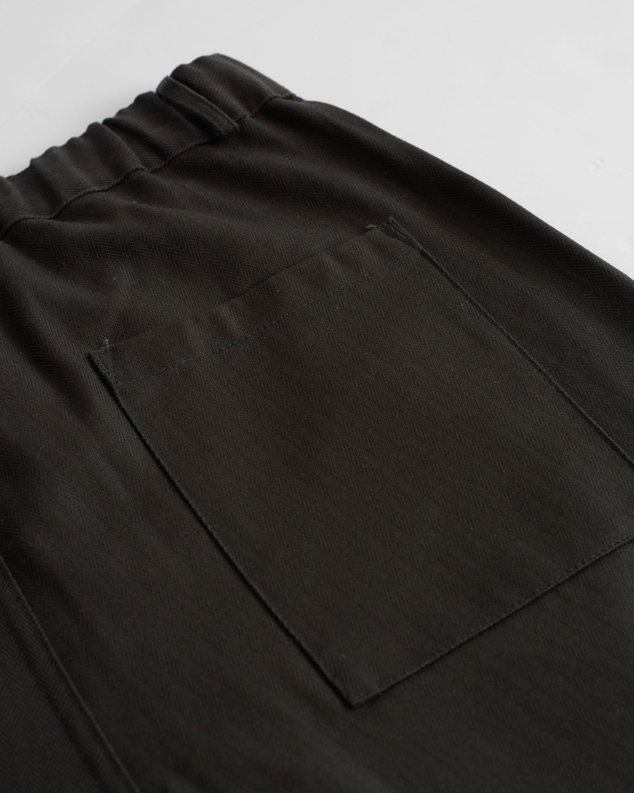 Closeup detail shot of back pocket on Bather men's deep green herringbone short