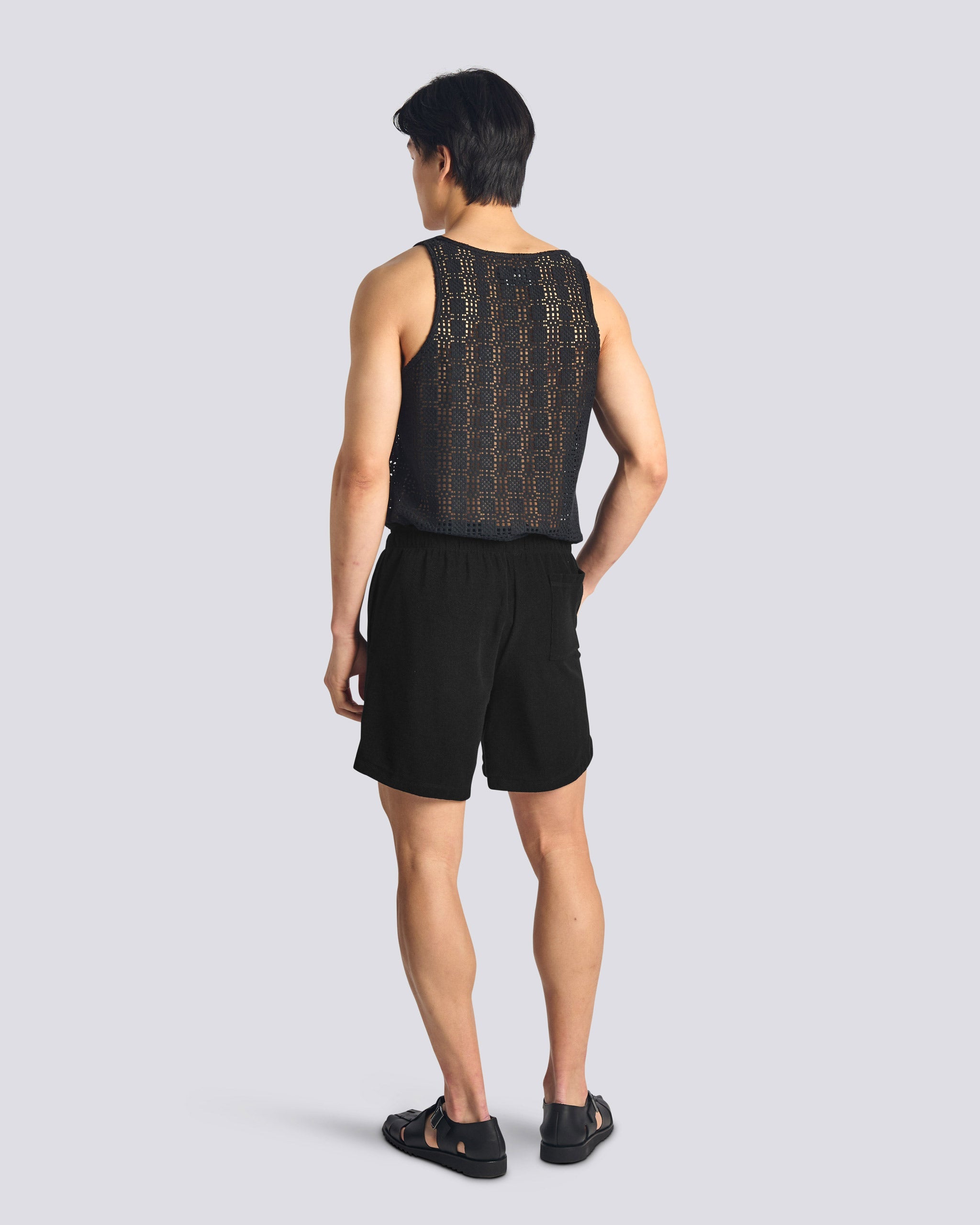 Bather men's black towel terry shorts with drawstring on model from the back on white background
