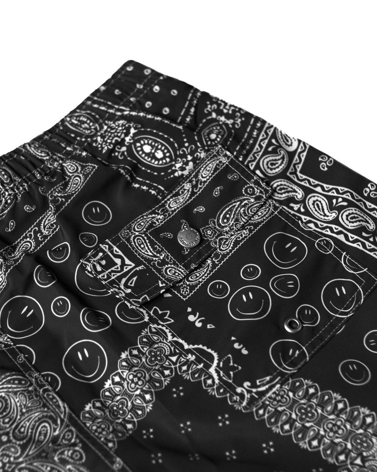 Back pocket close up of Black swim trunk with all-over bandana print