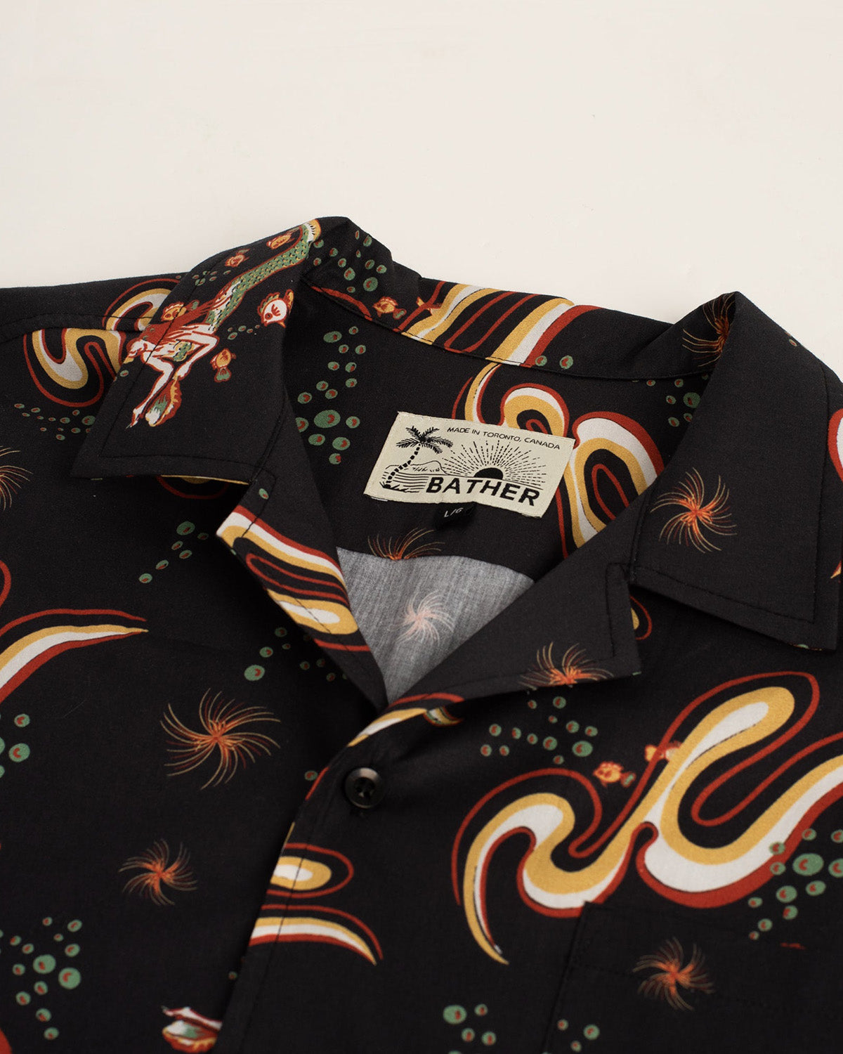 Close up of Black Bather camp shirt with siren pattern