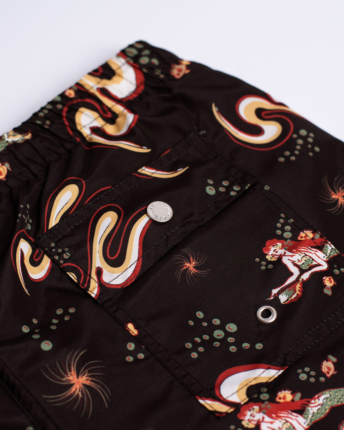 Close up of Black Bather swim trunk with siren pattern