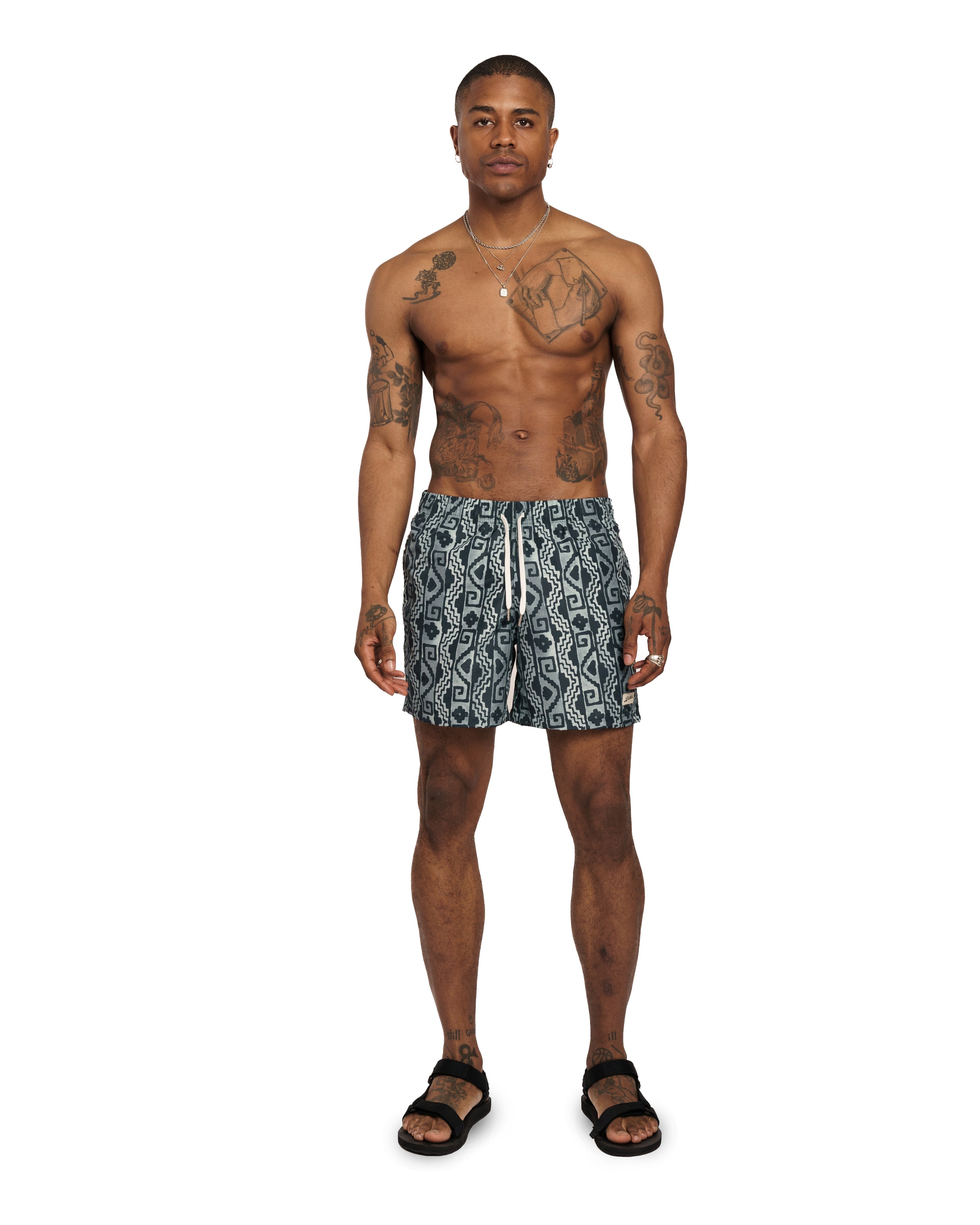 Model wearing Bather swim trunk with navy geometric pattern 