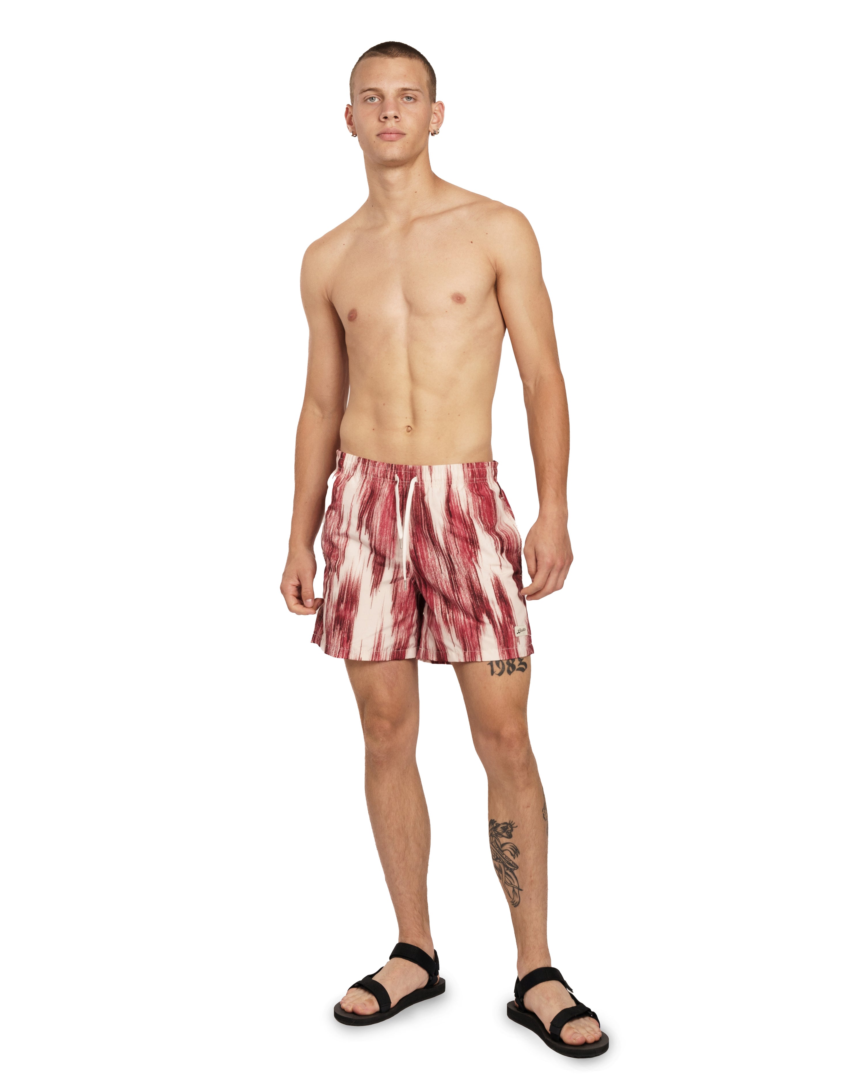 model wearing red and white Bather swim trunk with a color clashing pattern