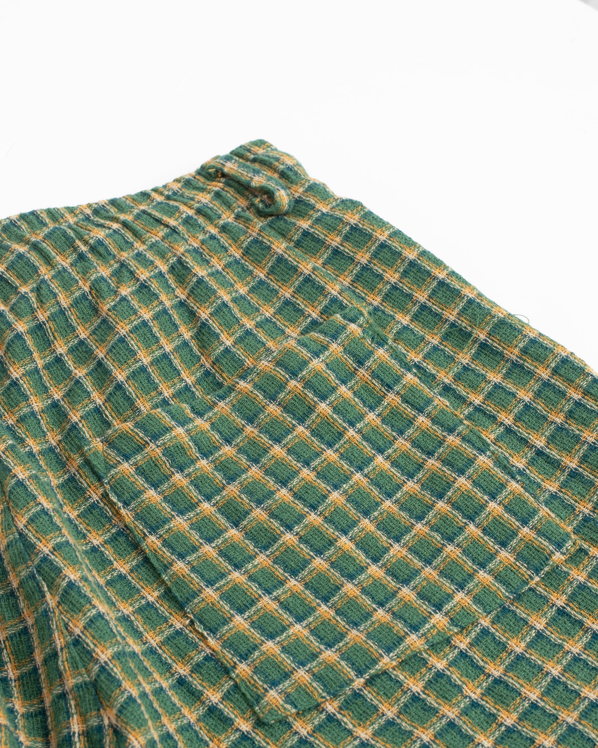 Close-up of back pocket on Bather men's green and yellow checkered drawstring shorts