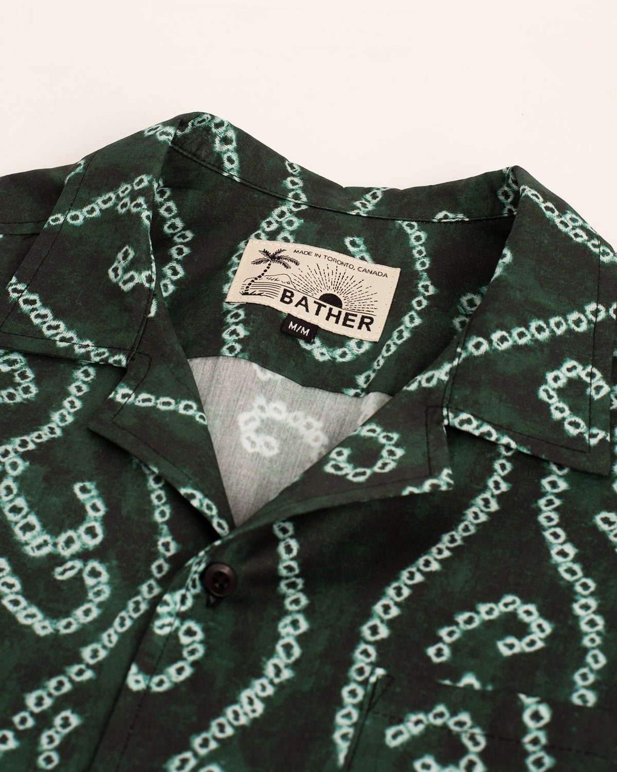 green Bather camp shirt with white shibori hook and loop pattern close up