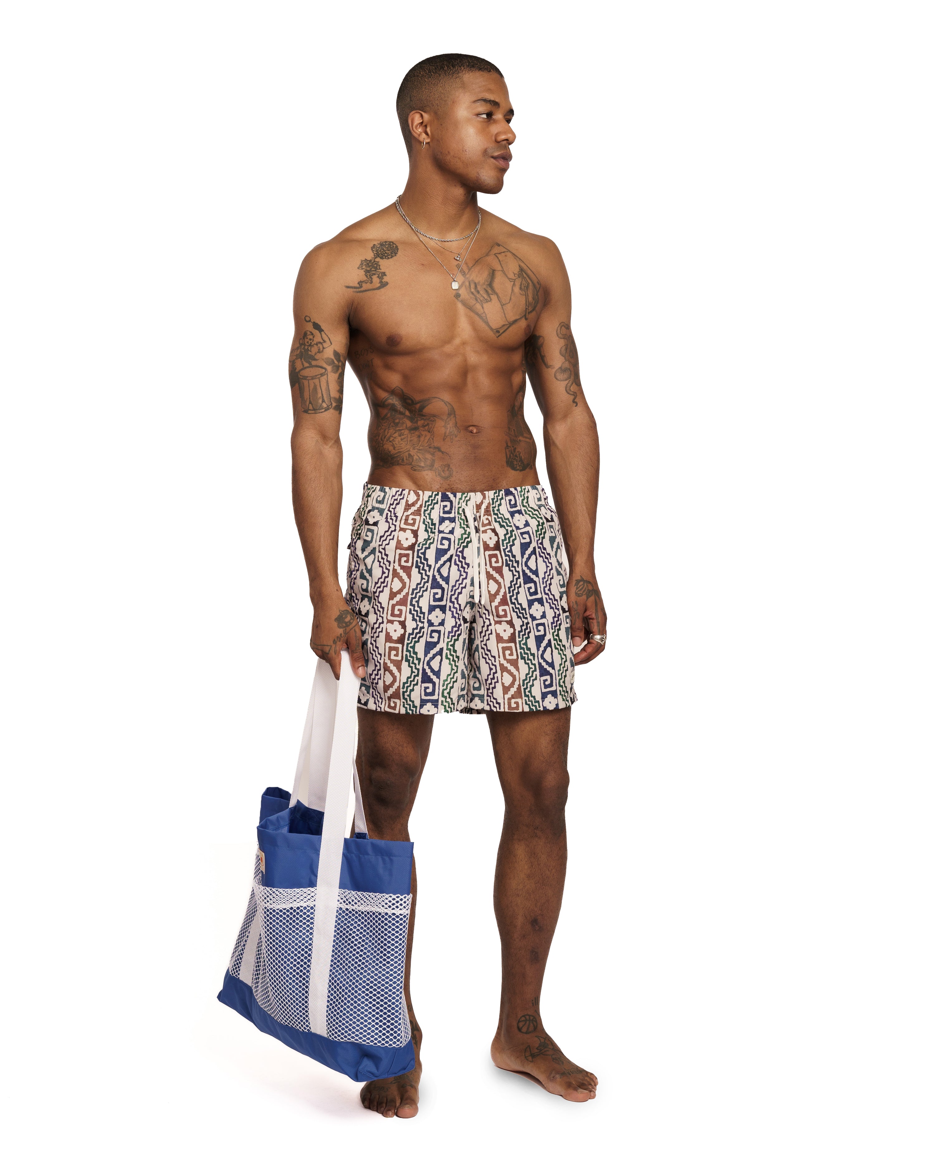 model wearing beige Bather swim trunk with multicolor geometric pattern