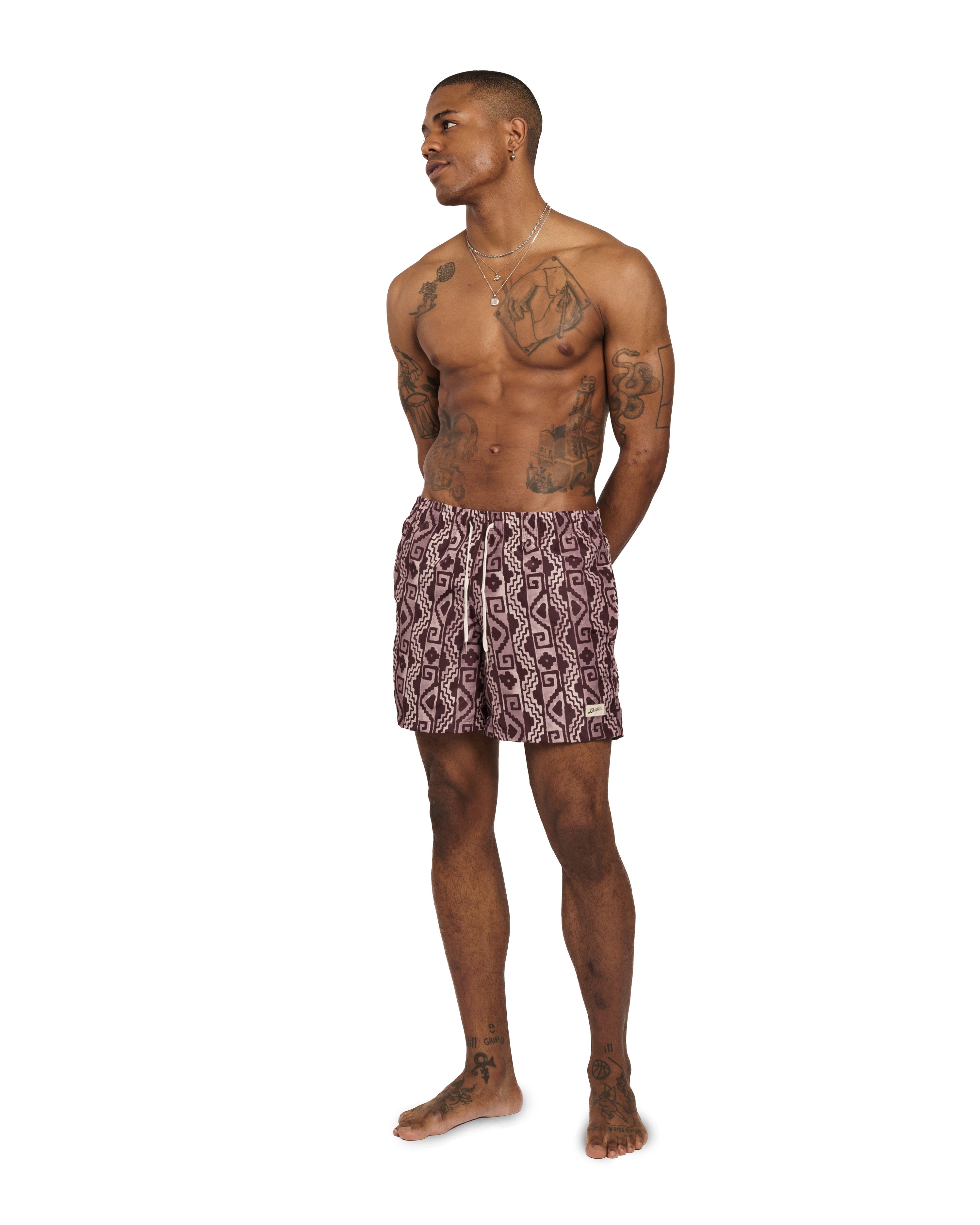 model wearing mahogony Bather swim trunk with geometric pattern